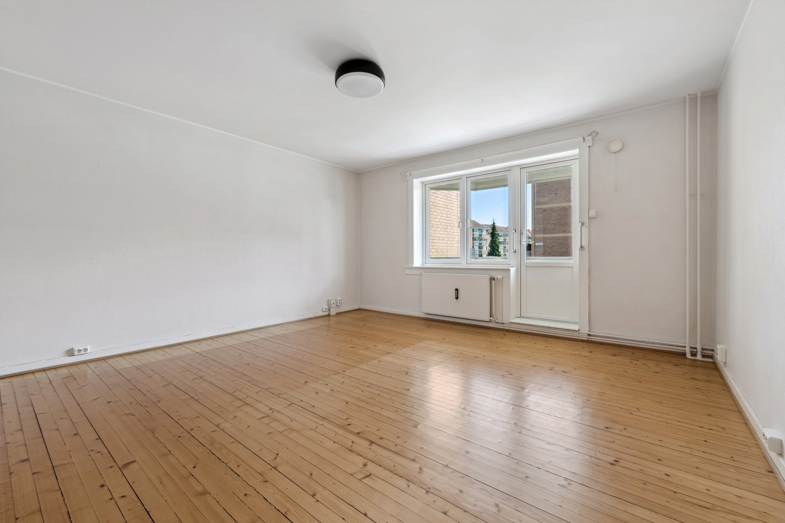 Lys og romslig stue med store vindusflater som slipper inn rikelig med lys. Balkongdør og vinduer fra 2016. Galleribilde