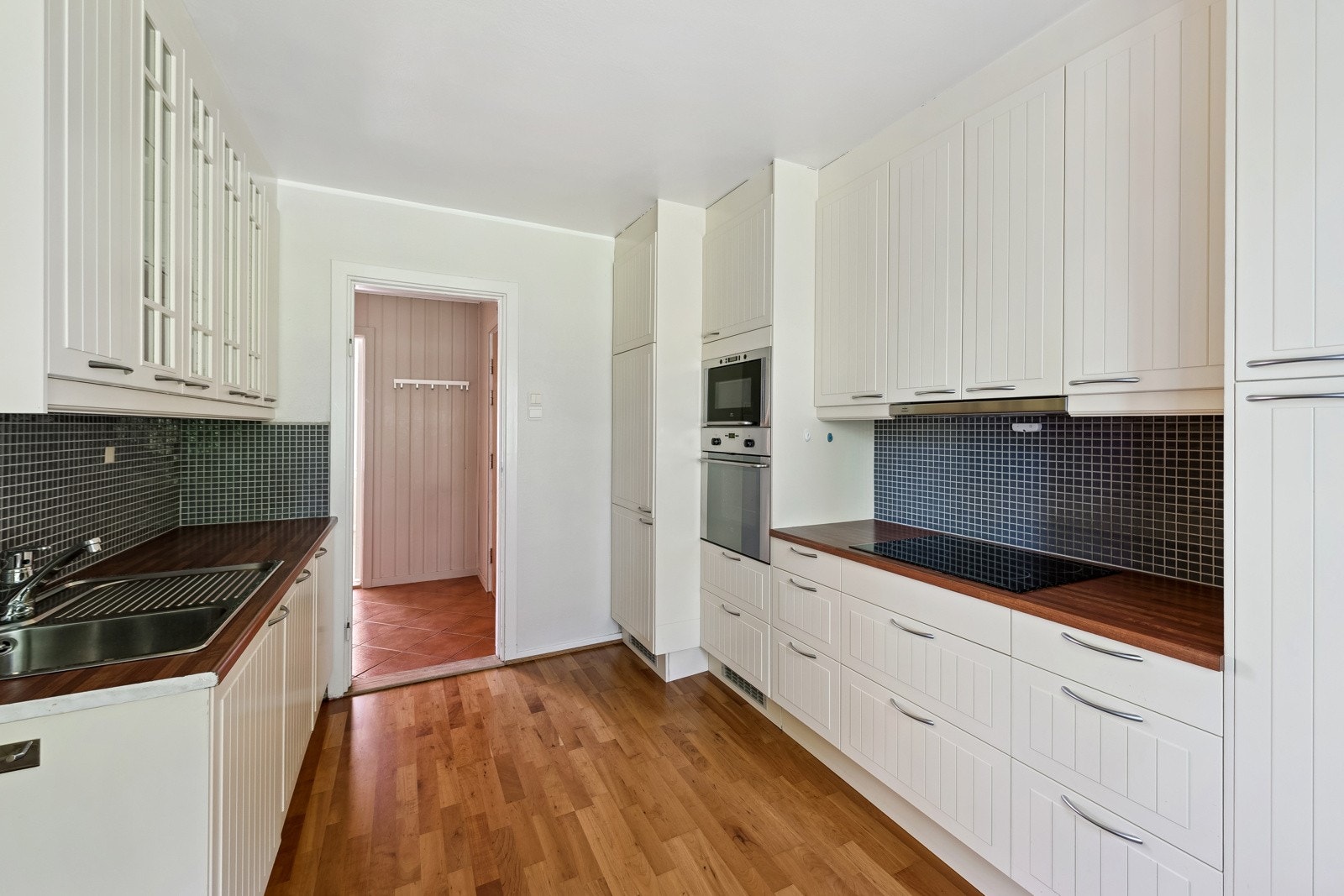 Mellom benkeplate og overskap er det flislagt for et praktisk og stilrent uttrykk. Under overskapene finnes både belysning og stikkontakter som gir god arbeidsbelysning og enkel tilgang til strøm. Galleribilde