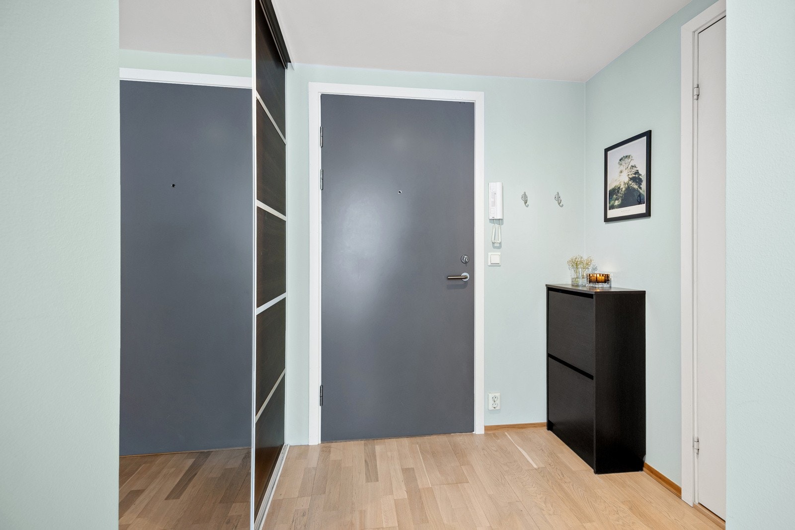 Innbydende entré som gir et godt førsteinntrykk av leiligheten. Her er det god plass til yttertøy i skyvedørsgarderobe. Galleribilde