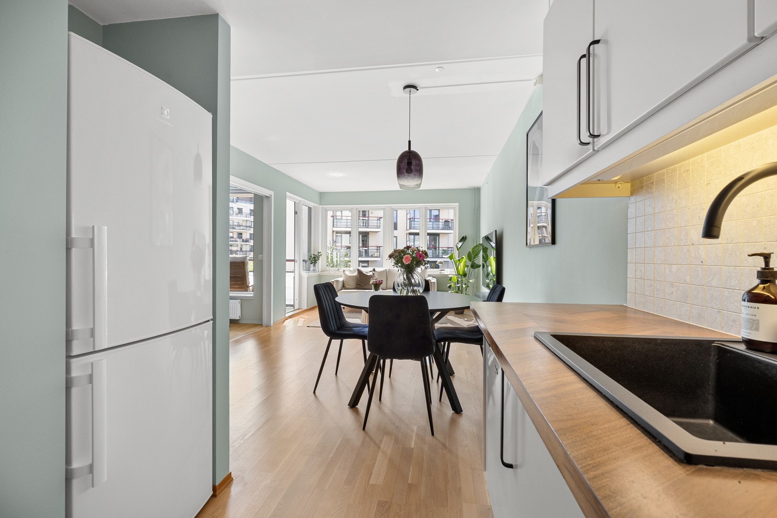 Integrert stekeovn og induksjonsplatetopp, og frittstående oppvaskmaskin og kjøleskap med fryser. Galleribilde