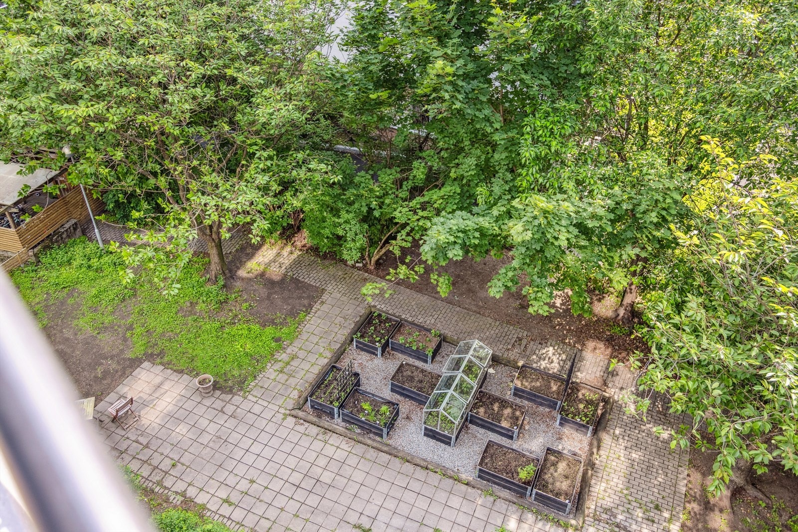 Utsikt fra balkongen ned mot felles bakgård med plantekasser Galleribilde