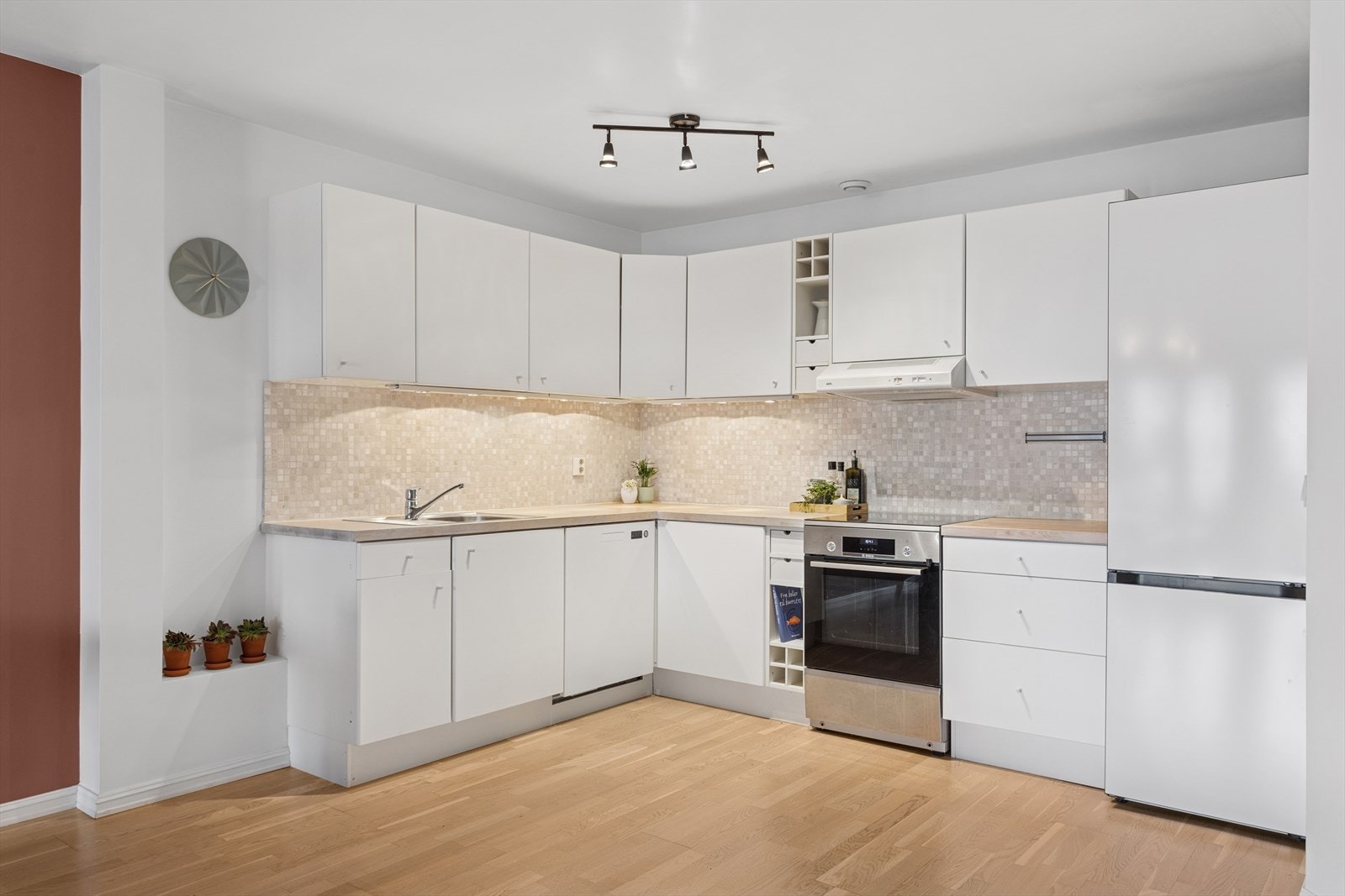 Kjøkkenet består av innredning med slette laminerte fronter, heltre eik benkeplate med fliser over, enkel oppvaskkum med benkebeslag, kjøkkenventilator i stål, samt frittstående komfyr, oppvaskmaskin og kjøl-/fryseskap Galleribilde