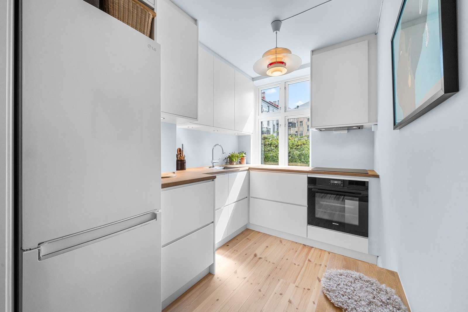 KVIK kjøkken fra 2024 som er innredet med glatte fronter og heltre benkeplate. Galleribilde