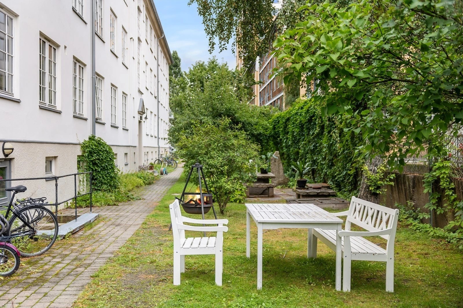 Idyllisk og frodig bakhage med hyggelige sittegrupper. Galleribilde