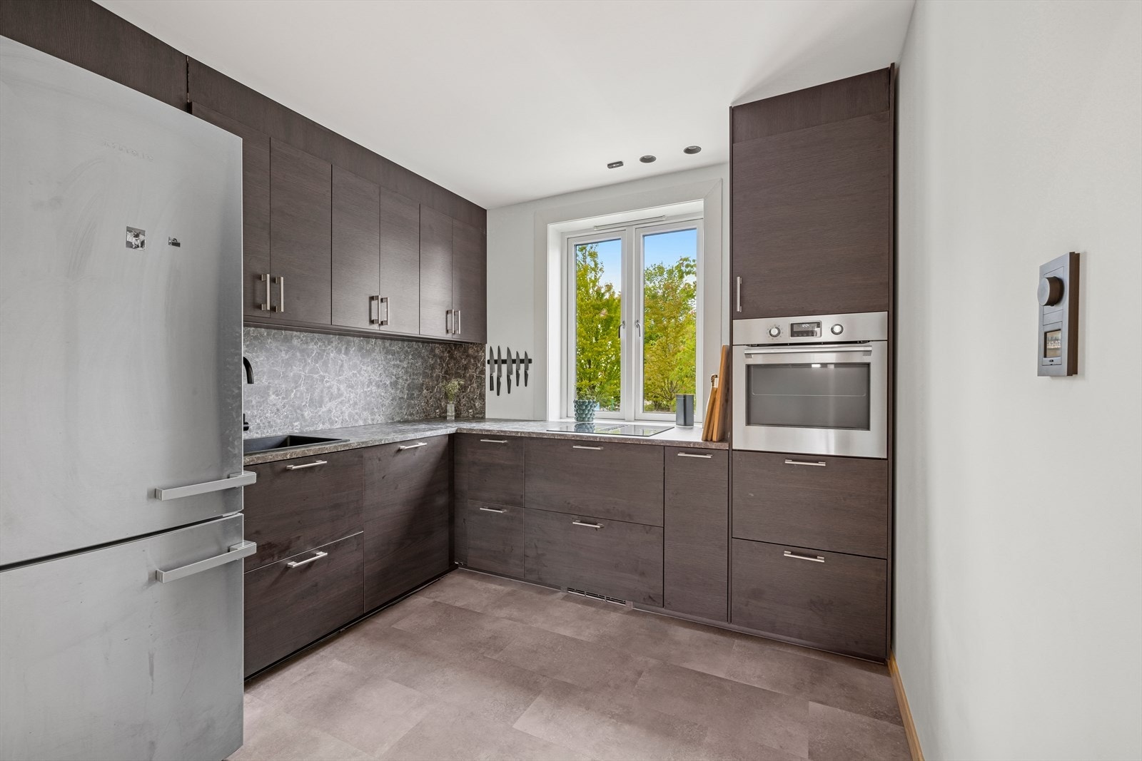 Kjøkkenet er moderne og tidløst, praktisk adskilt fra stueområdet. Galleribilde