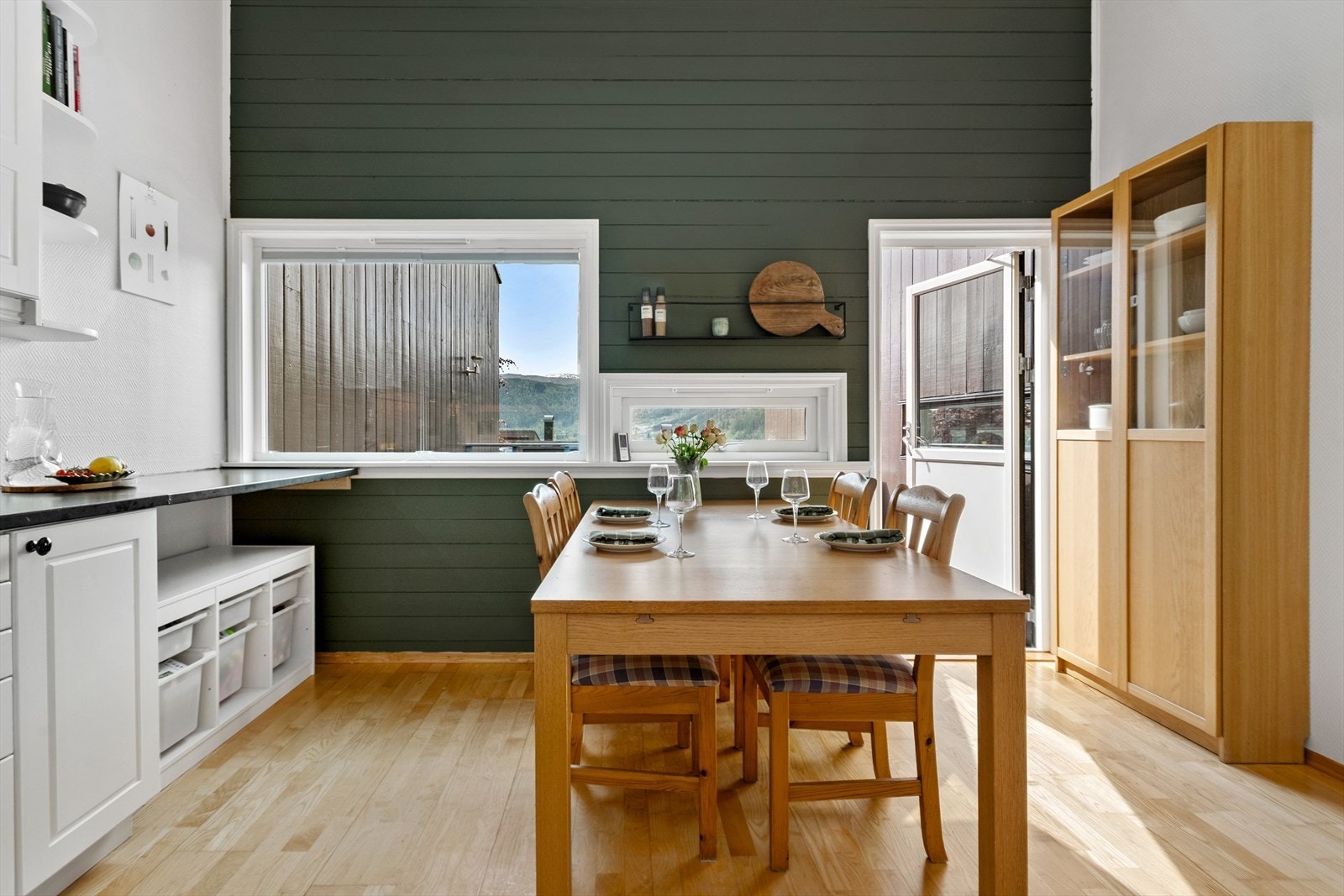 Fra kjøkkenet er det utgang til sørvendt veranda og platting/hage på andre siden av huset. Galleribilde