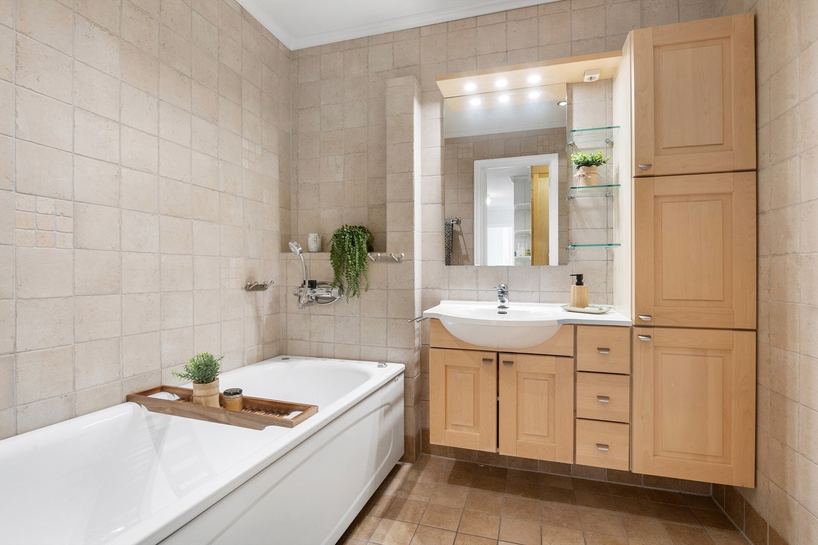 Badet er innredet med badekar, toalett og innredning med servant. Galleribilde