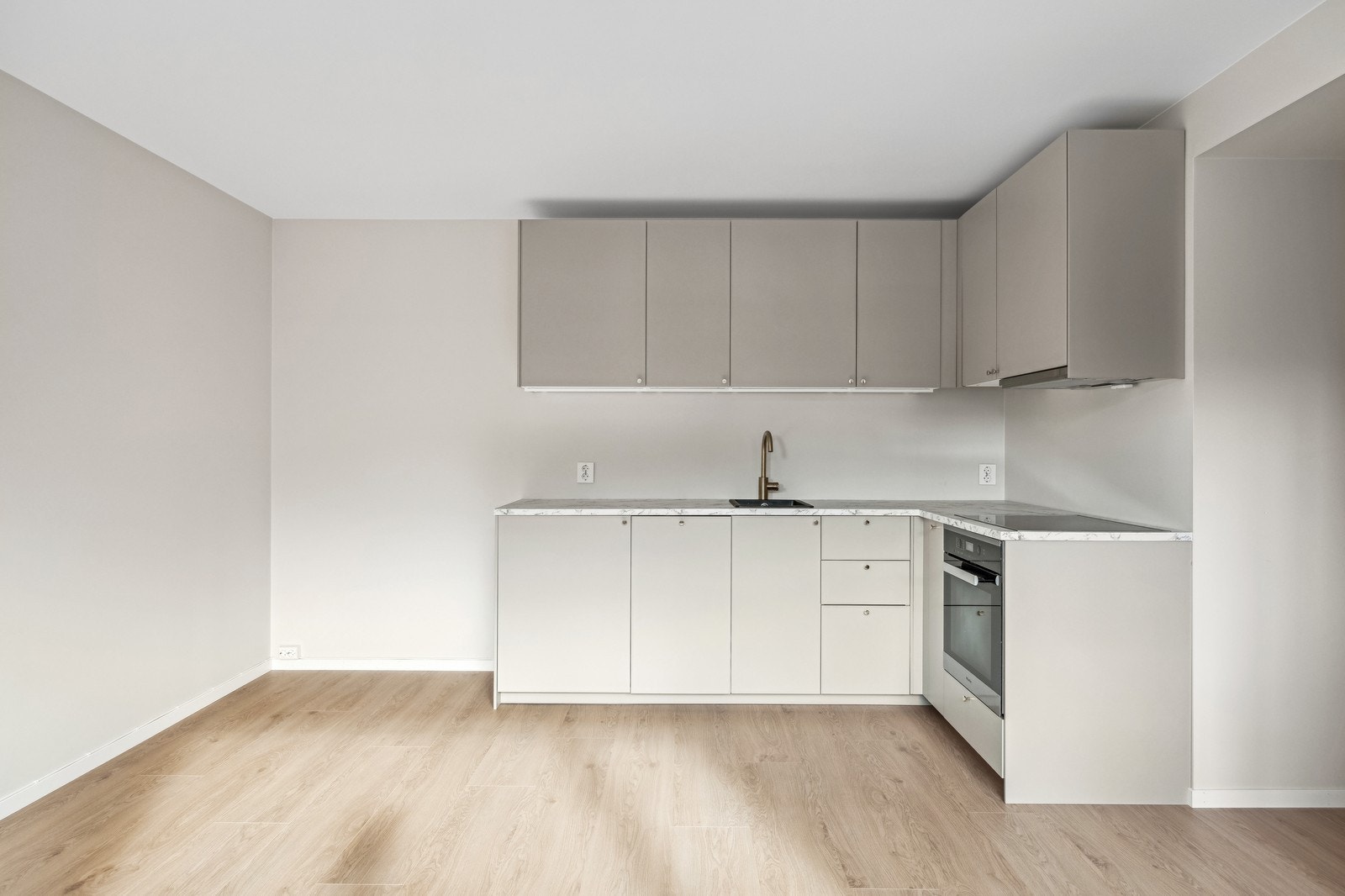 Kjøkken fra IKEA. Fargen er beige med gull-detaljer. Laminat benkeplate i marmor imitasjon. Galleribilde