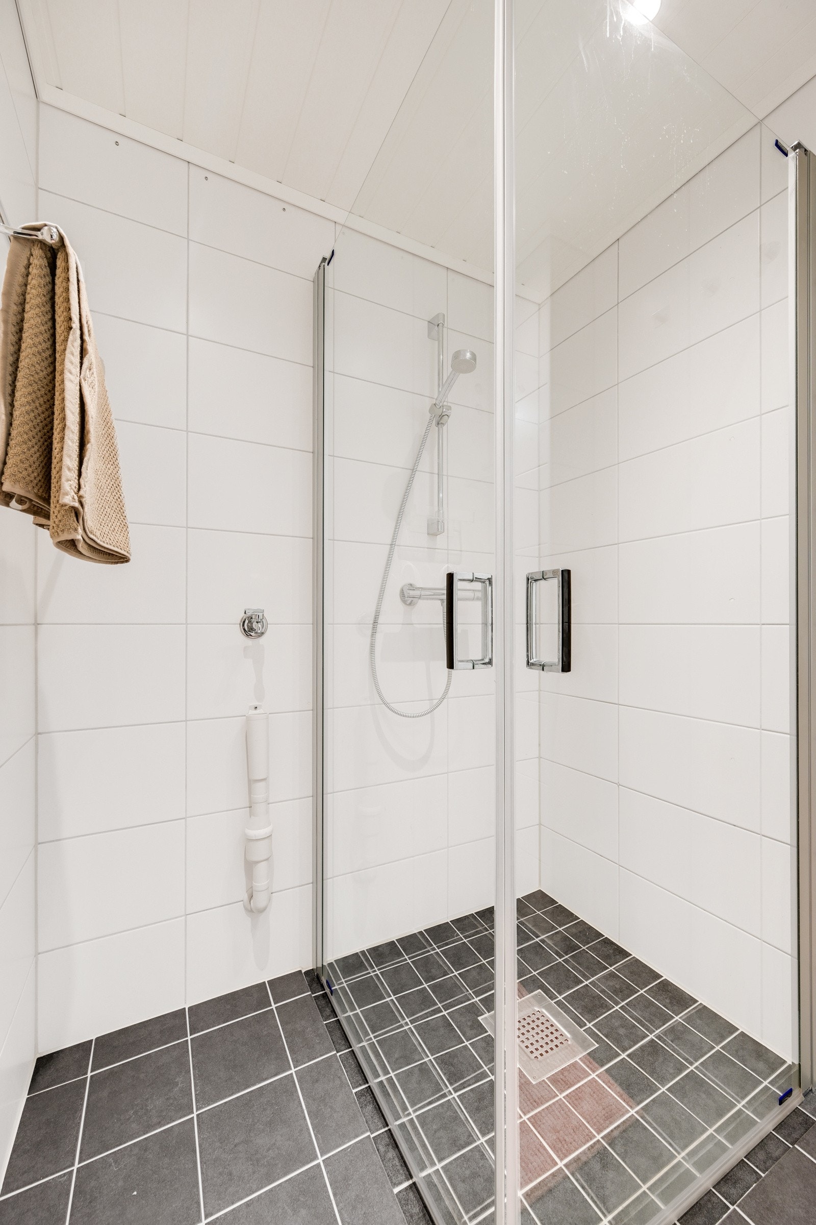 Dusjhjørne med foldedør og opplegg for vaskemaskin - det er i tillegg felles vaskerom i kjelleren Galleribilde