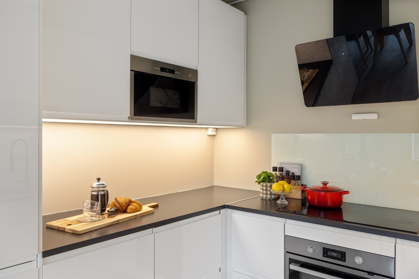 Integrerte hvitevarer fra Whirlpool i form av kjøl/fryseskap, oppvaskmaskin, mikro, stekeovn og induksjon platetopp (75 cm). Galleribilde