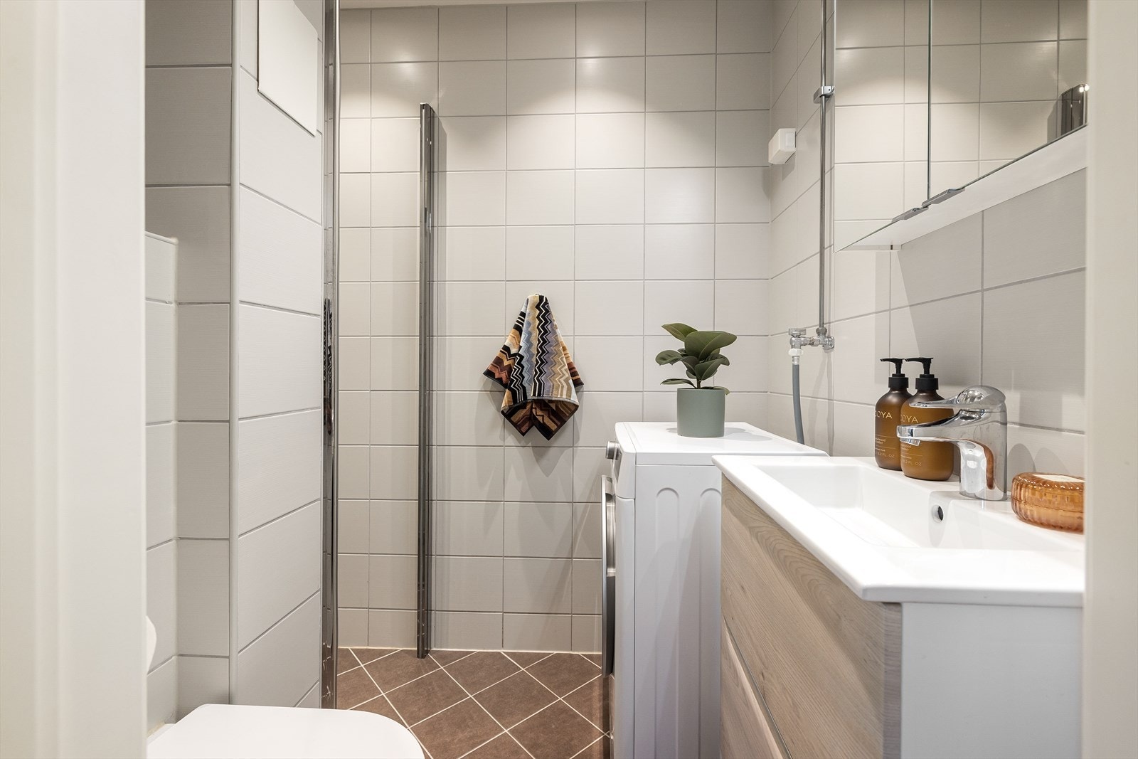 Delikat, flislagt baderom i tidløs stil, med varmekabler i gulvet og downlights i himling. Galleribilde