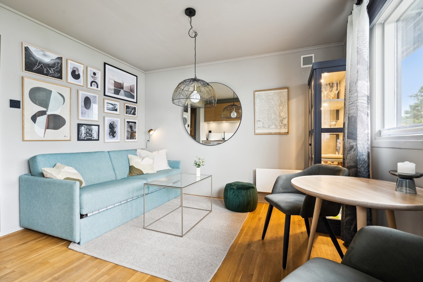 En koselig stue med plass til sofa og spisebord. Også i leiligheten er det fin utsikt og mye lys fra sørvendte vinduer. Galleribilde
