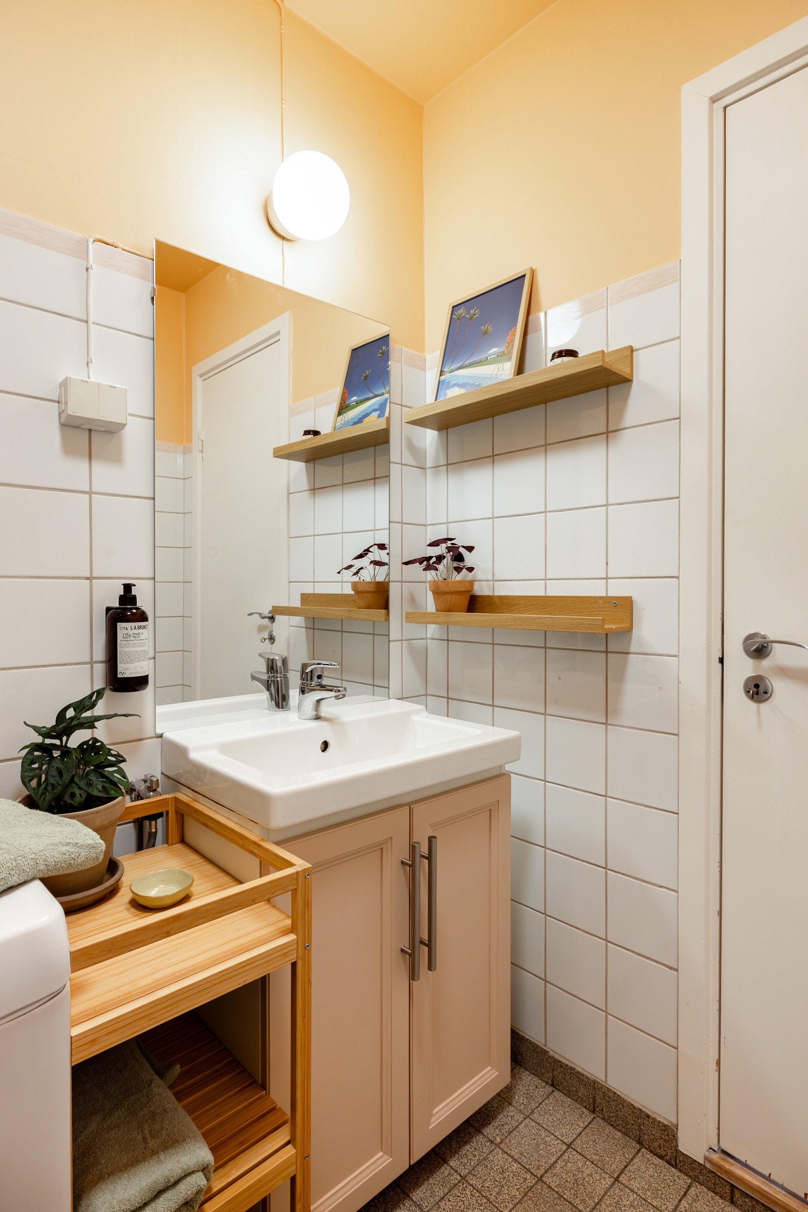 Innredningen er også malt i en fin farge og har ovenpåliggende servant. Over servanten er det speil, vegghengt belysning og eikemønstrede hyller for oppbevaring og dekor. Galleribilde