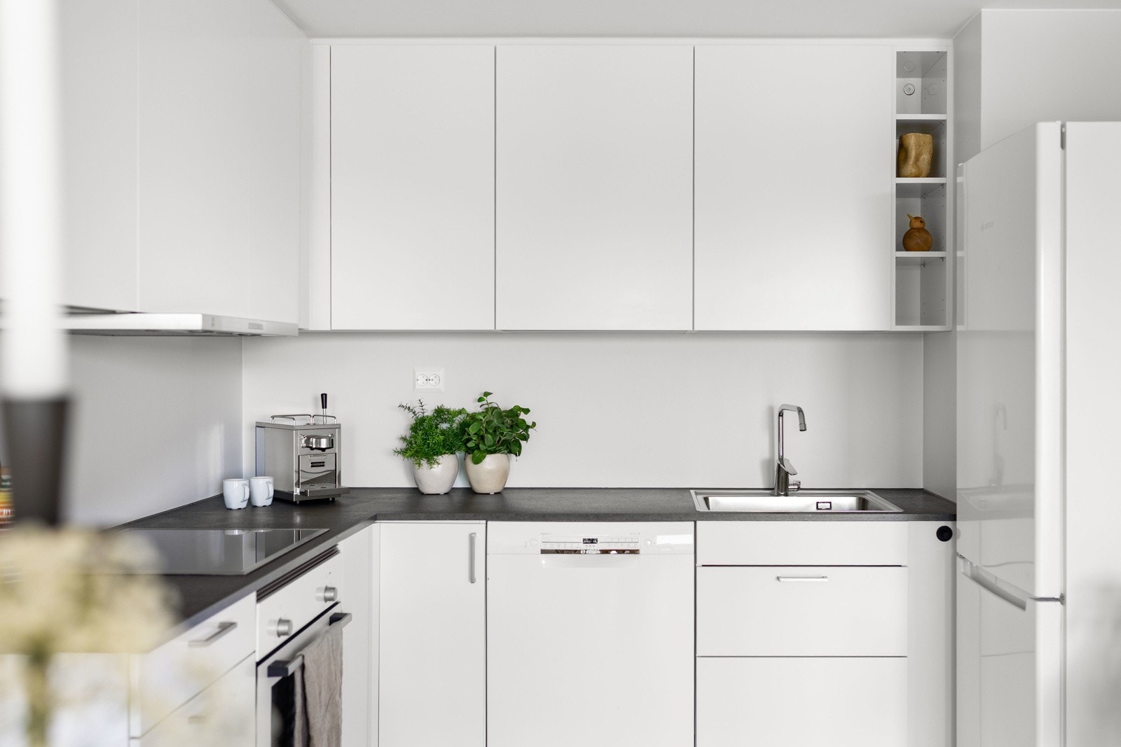 Kjøkkenet har stilren og moderne innredning med glatte fronter og benkplate av laminat. Galleribilde