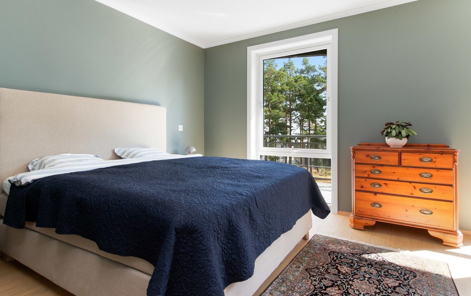 Rommet har malte vegger i en grågrønn farge og enstavs parkettgulv med gulvvarme. Galleribilde