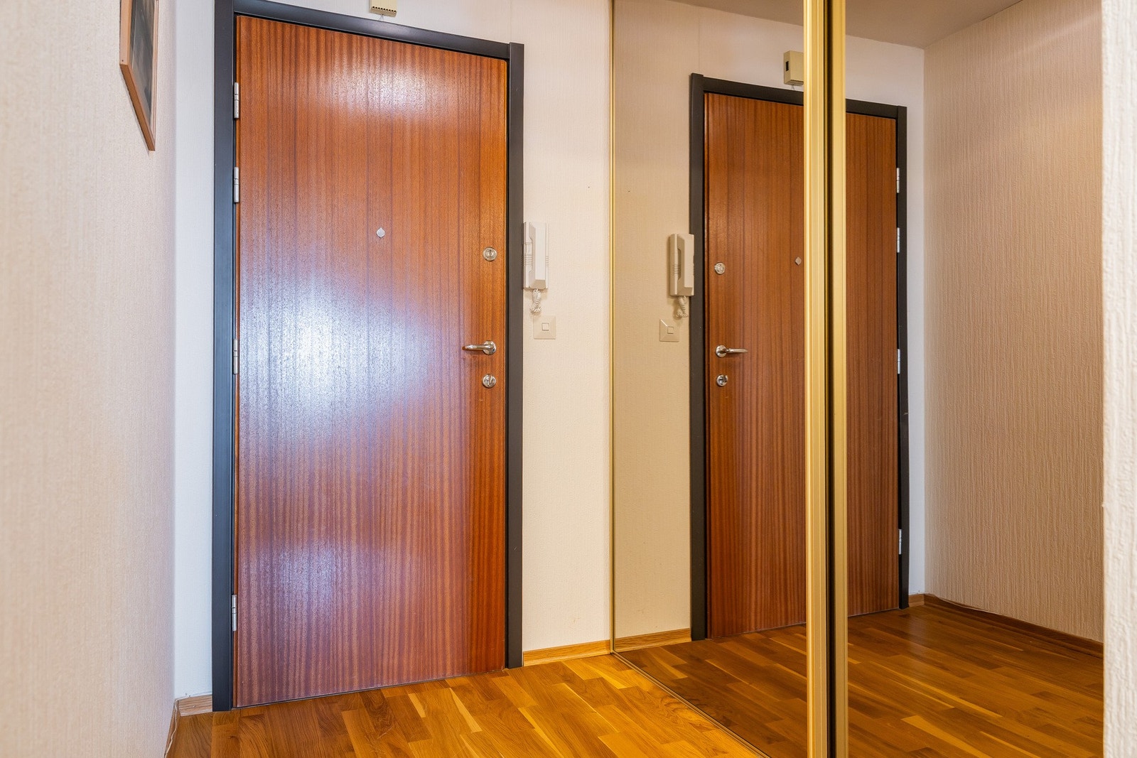 Innbydende entré med parkett på gulv og skyvedørsgarderobe. Galleribilde