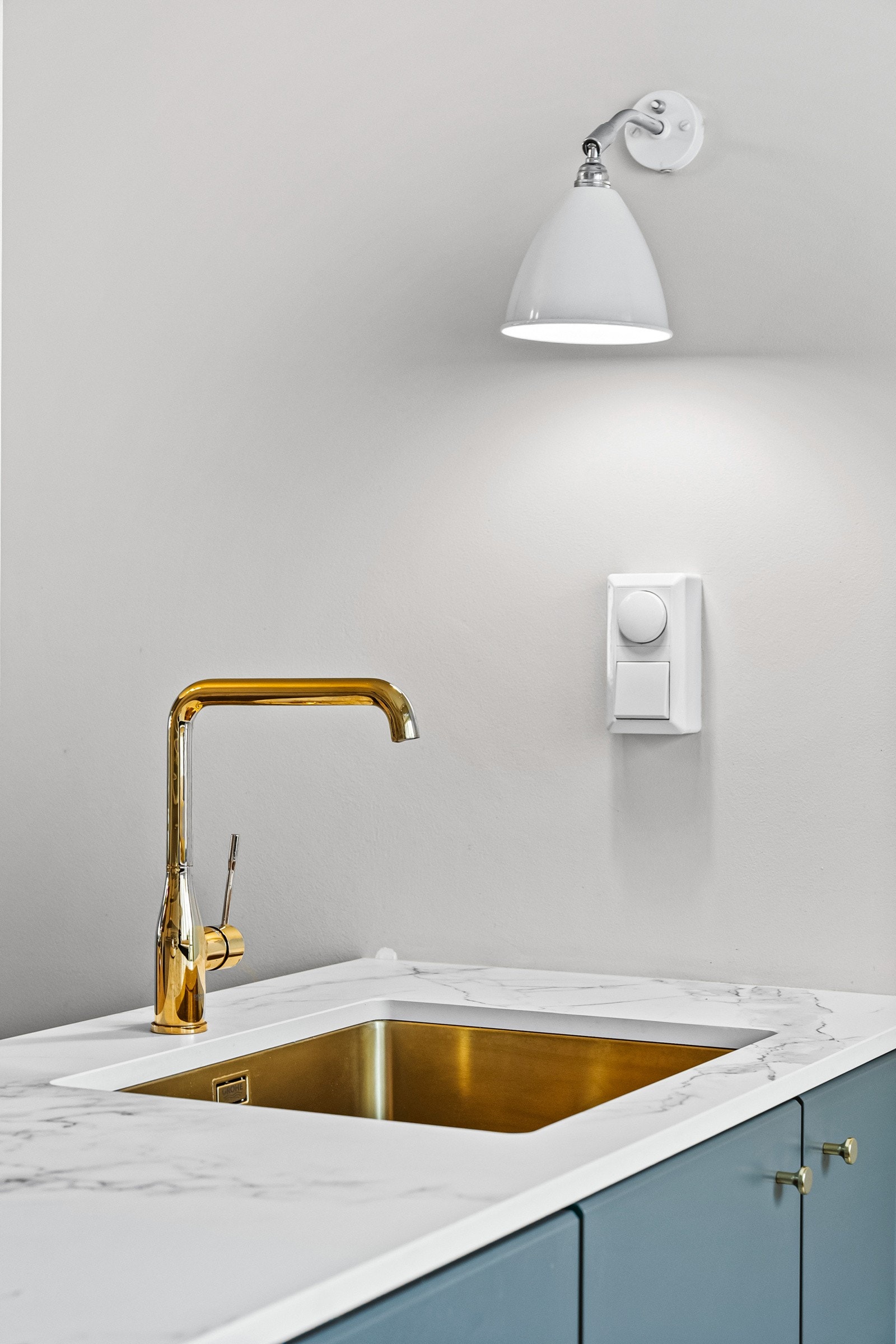 Den lyse komposittstein-benkeplaten har en underlimt kum og et stilrent ett-greps armatur i messing, som tilfører et eksklusivt preg Galleribilde