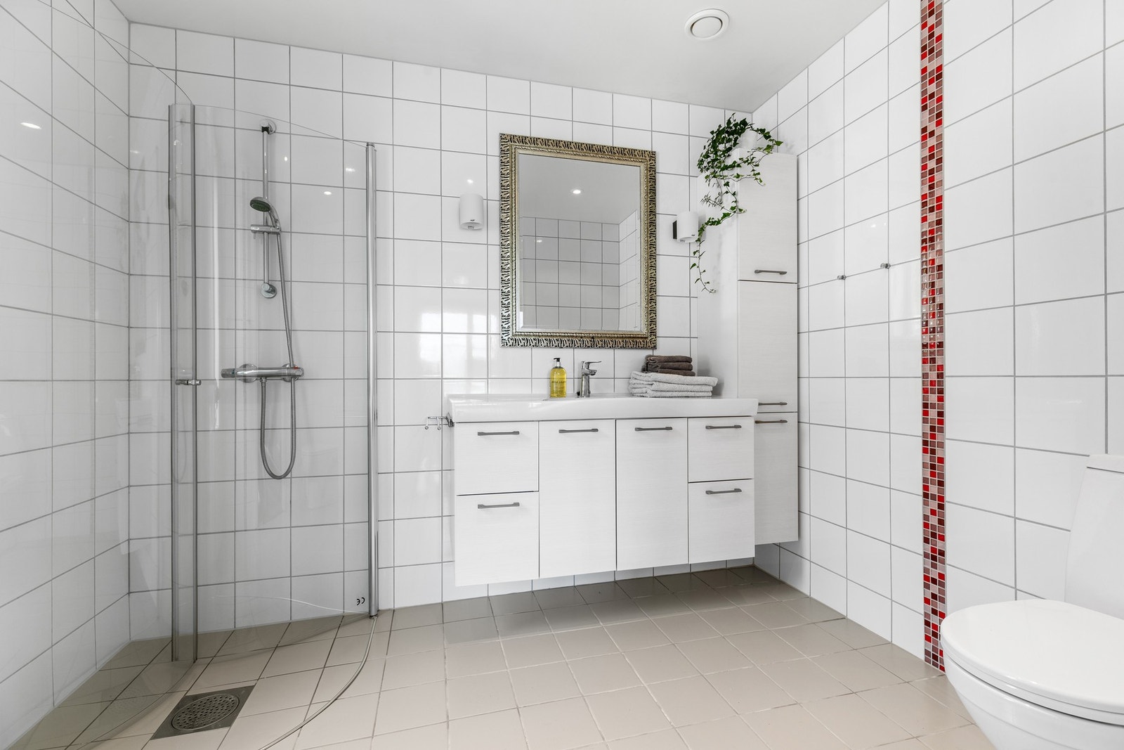 Badet er utstyrt med servant m/skapseksjon, toalett, høyskap og dusjhjørne med innsvingabare glassdører Galleribilde