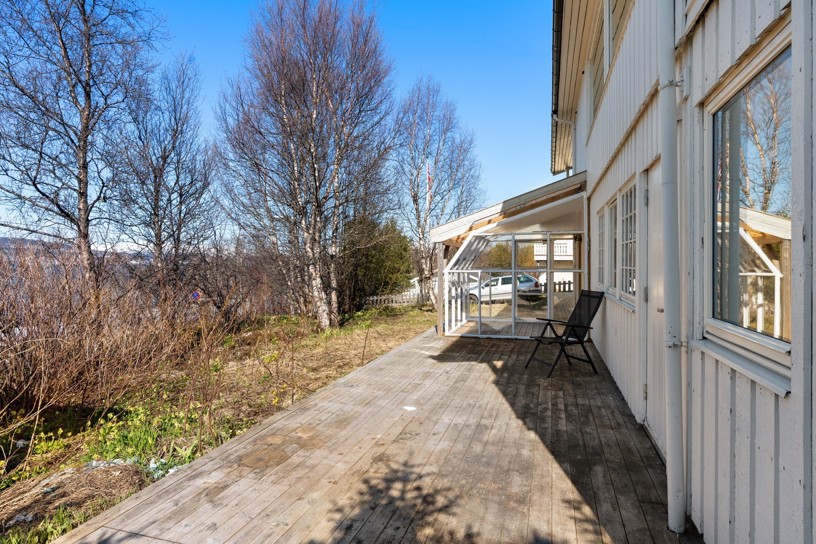 Stor terrasse og innglasset veranda montert på terrassen. Her er det god plass til utemøbler og grill.