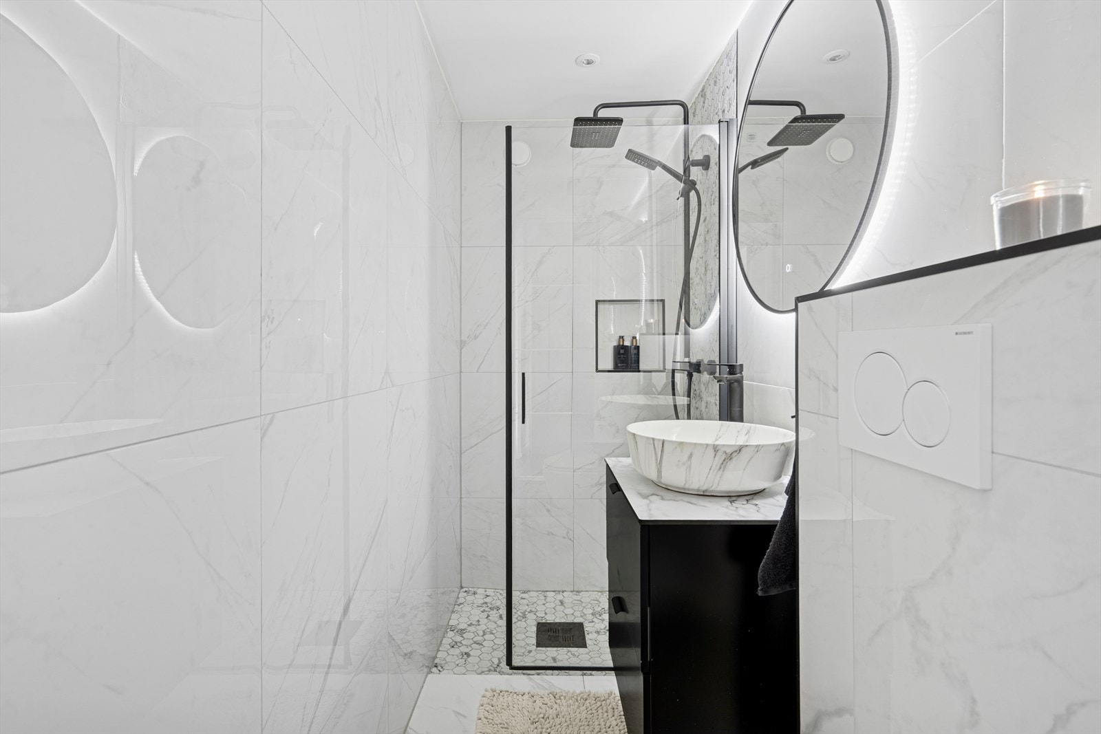 Det andre badet, som nås fra entréen, har tilsvarende stil og utførelse. Begge badene er helflisede og har behagelig gulvvarme, noe som gir ekstra komfort året rundt. Galleribilde