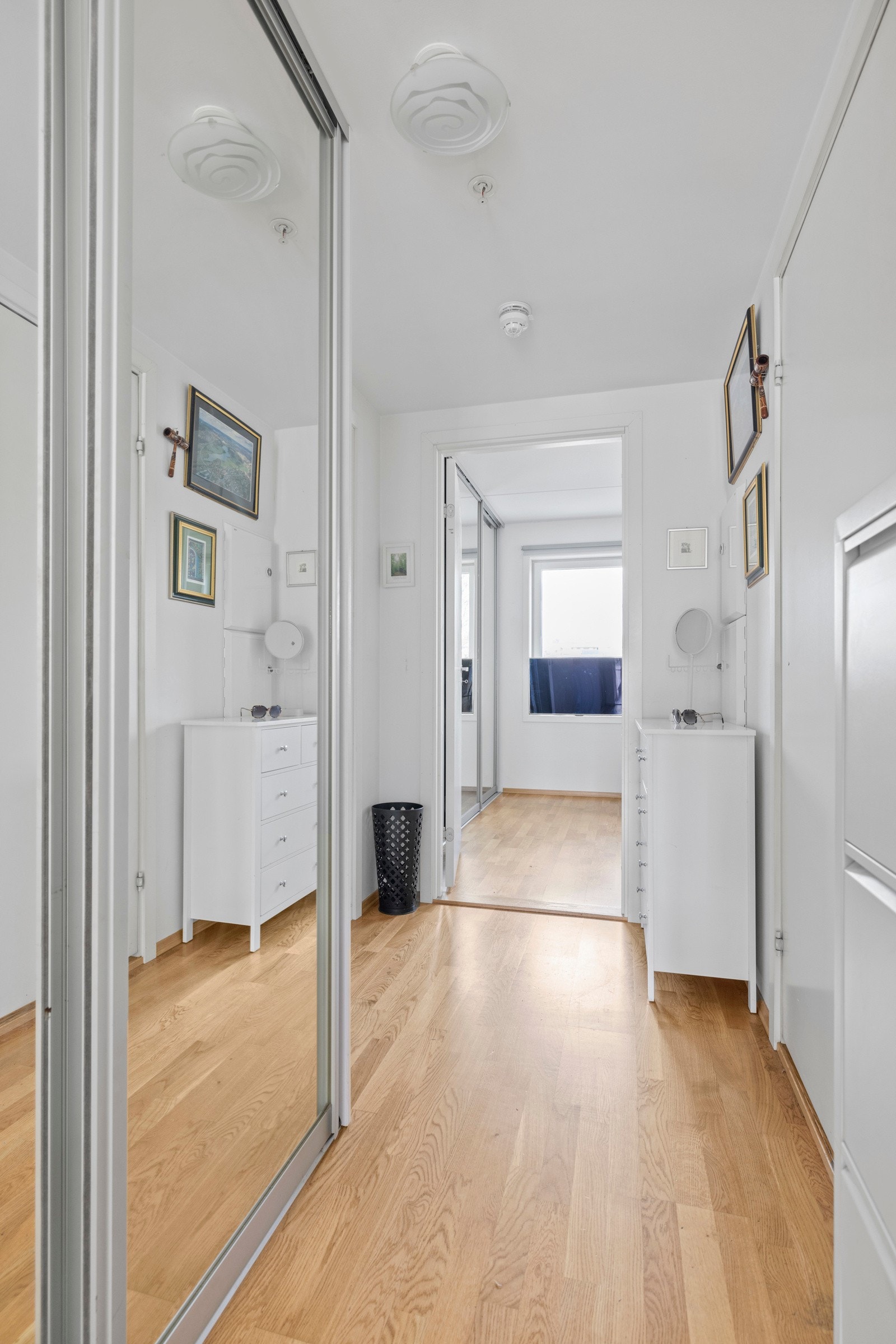 Boligens entre har også parkettgulv, med nok en skyvedørsløsning med speilfronter Galleribilde