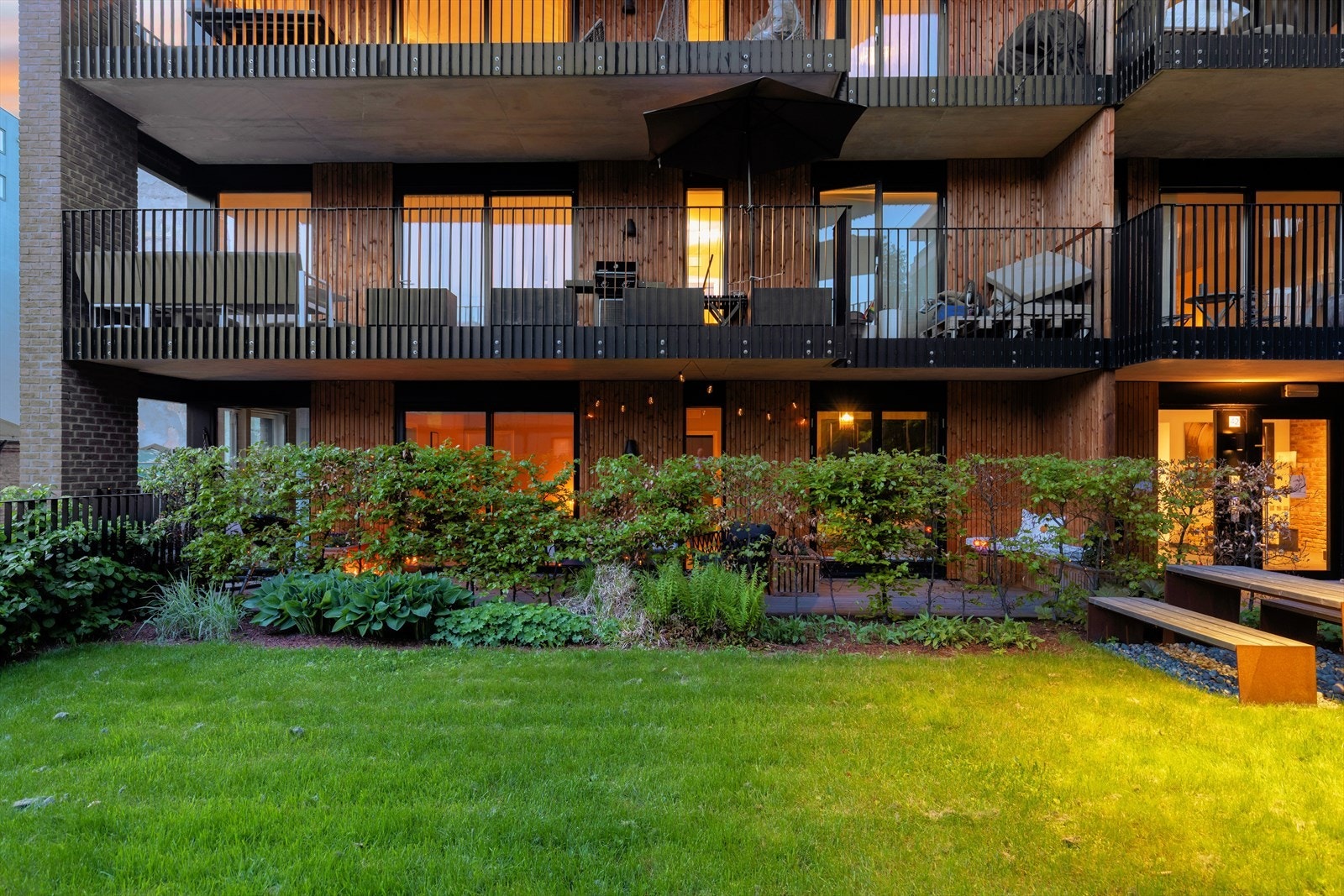 Borettslagets tomt er pent opparbeidet med beplantning, plen, belysning, sittegrupper og gangstier. Galleribilde