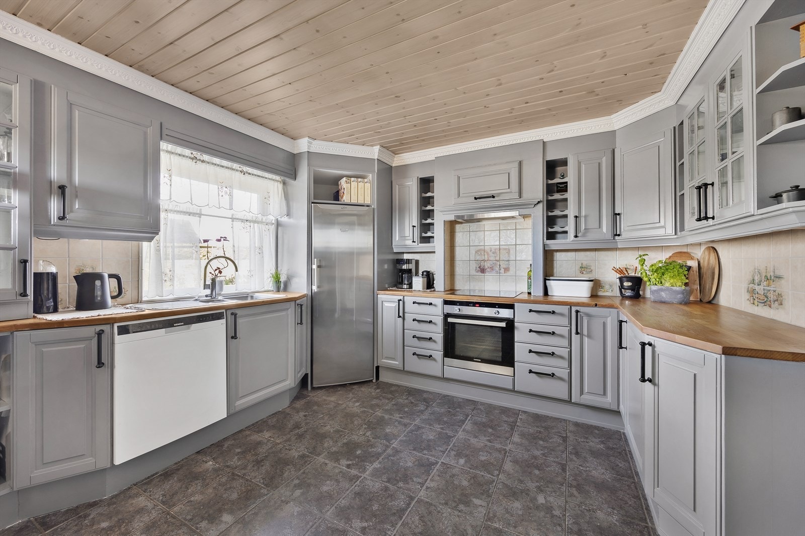 Kjøkkenet ligger i eget rom og har godt med skap- og benkeplass. Galleribilde