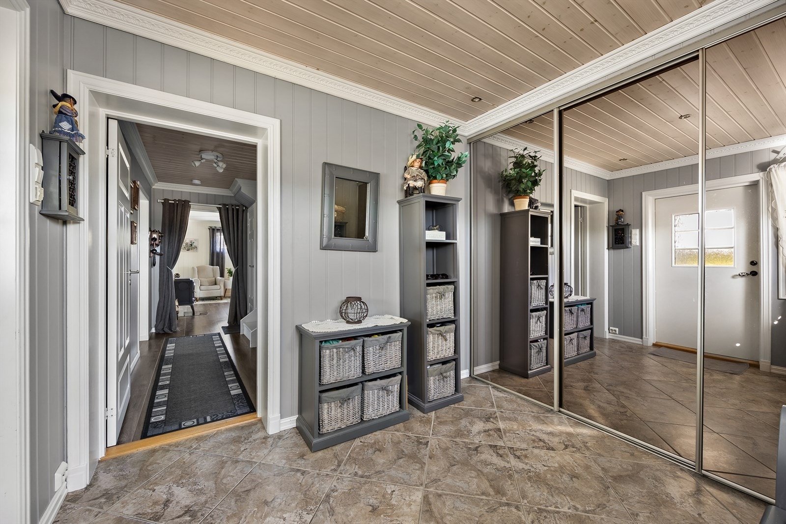 Langs den ene veggen ryddes yttertøy og sko enkelt bort i en stor og plassbygget skyvedørsgarderobe med speilfronter. Galleribilde