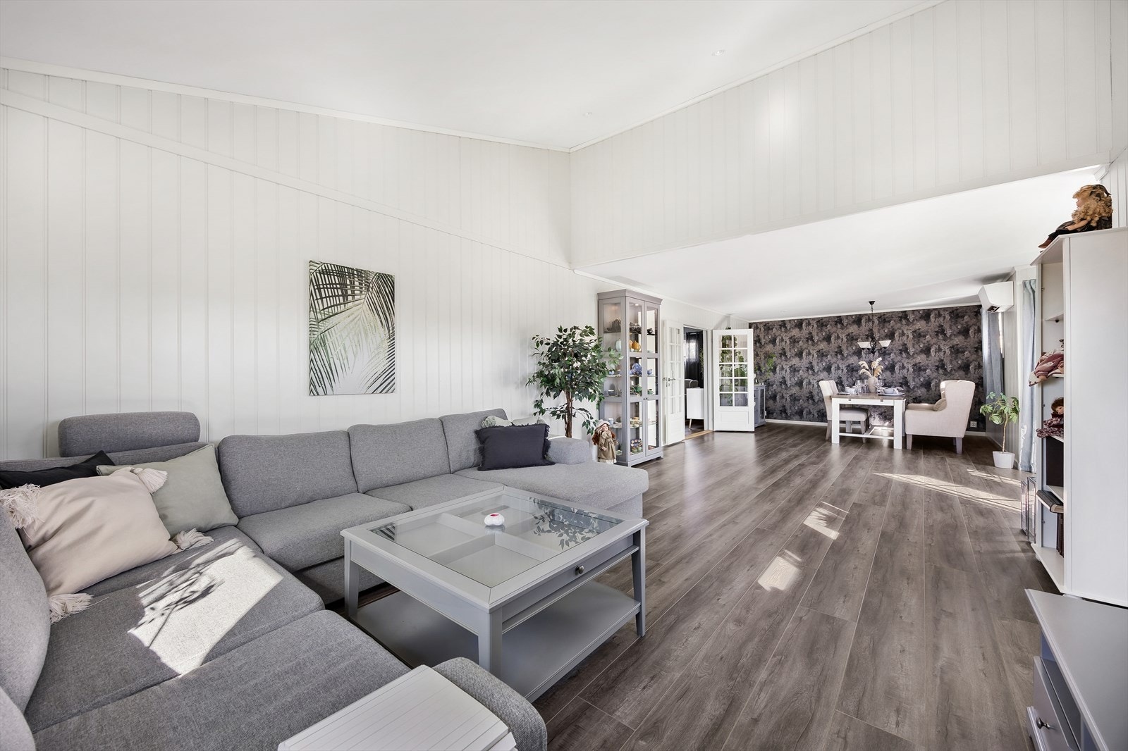 Begge stuene har gulv med 1-stavs laminat, i en kombinasjon med lysmalte vegger og en grå tapetvegg for fin kontrast. Galleribilde