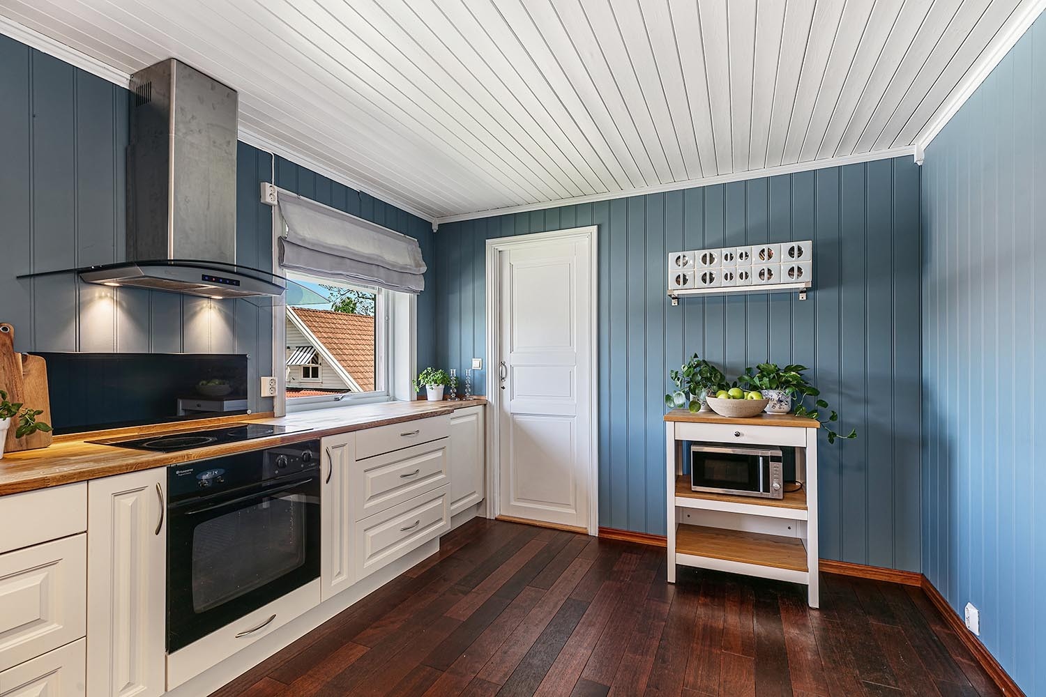 Stort kjøkken med spiseplass og dør til kjølerom Galleribilde