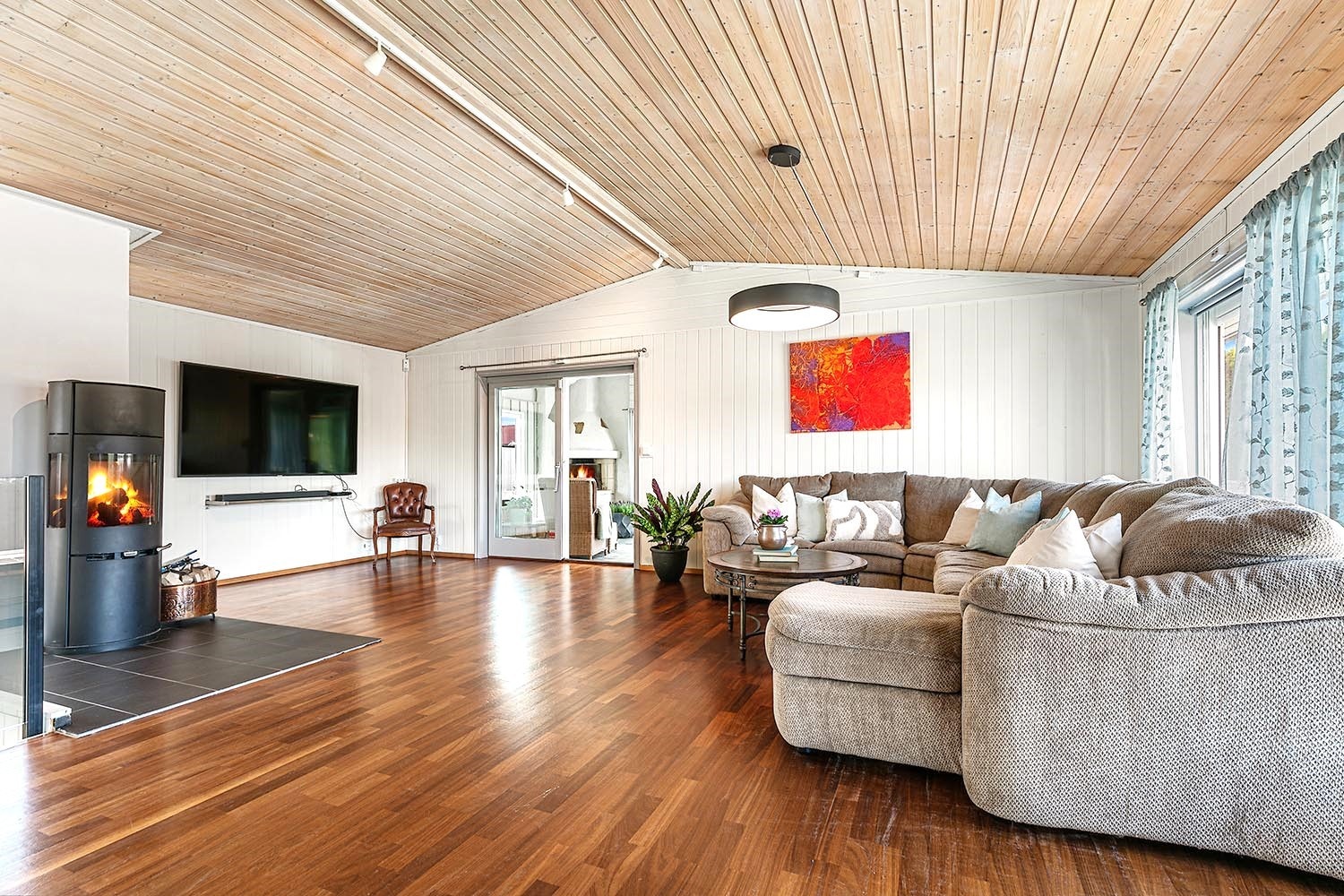 Stor stue med fin utsikt og utgang til hagestue, terrasse og bassengområdet Galleribilde