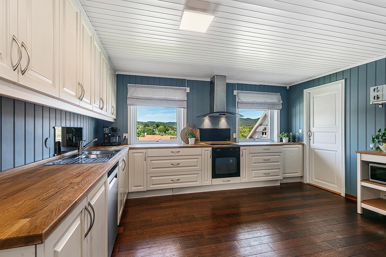 Stort kjøkken med spiseplass og dør til kjølerom Galleribilde