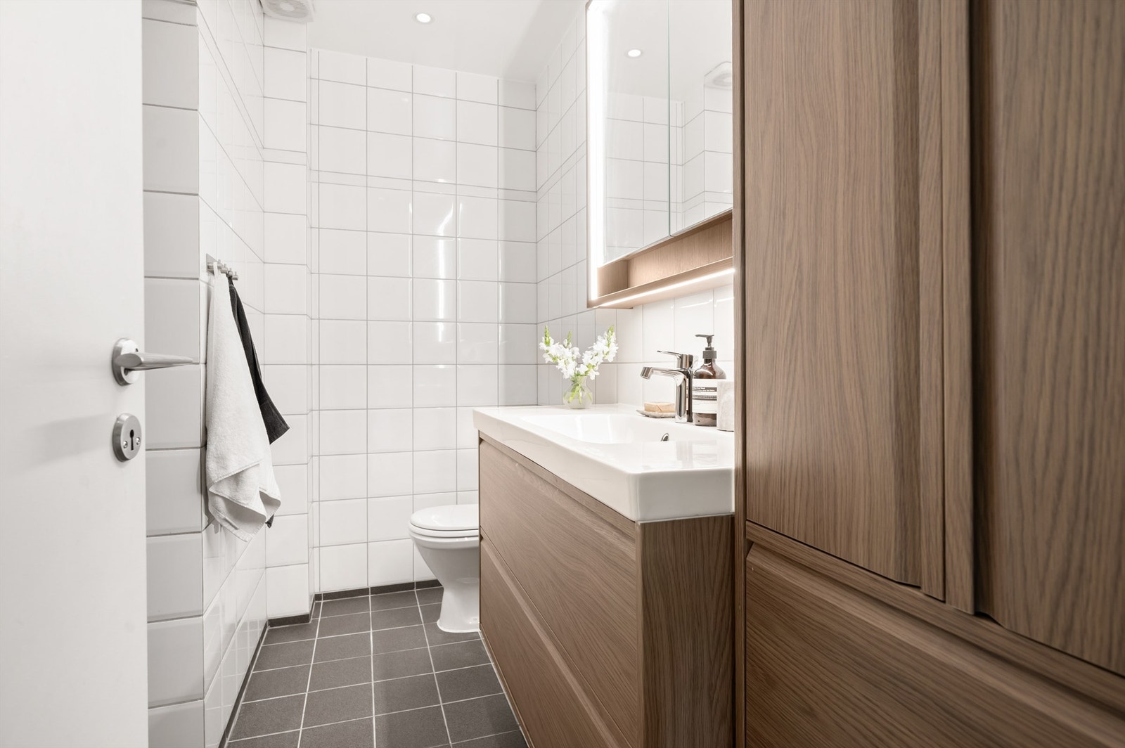 Lyst og pent baderom med flislagte overflater, downlights i himlingen og behagelig gulvvarme. Galleribilde