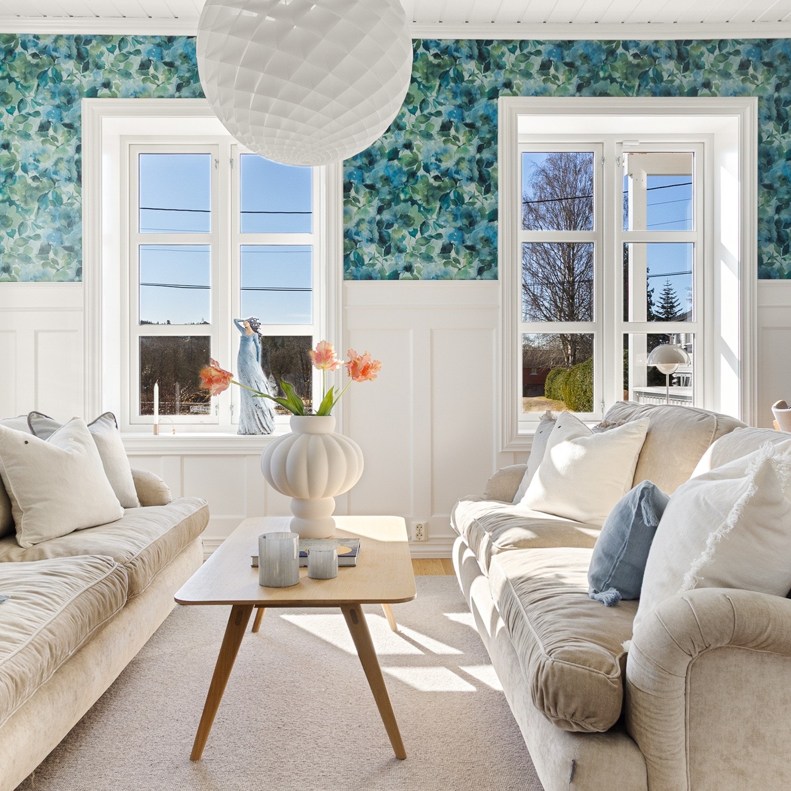 Lys og delikat stue med flott tapet og høy brystpanel. Galleribilde