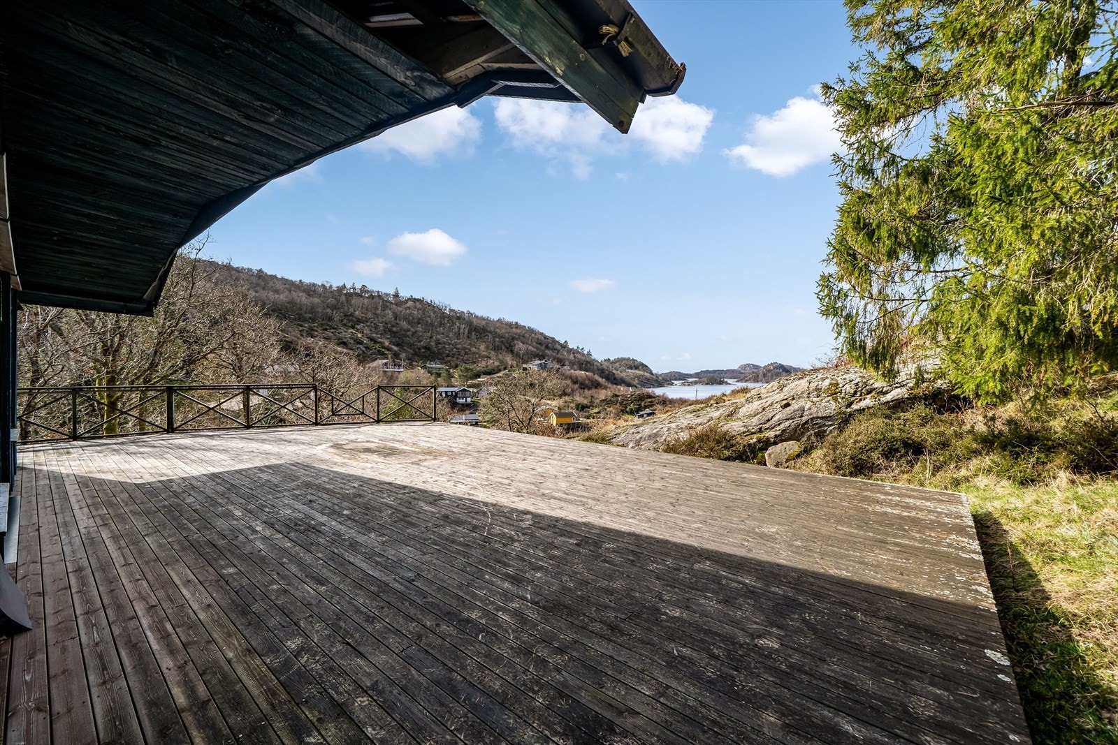 Romslig terrasse med vakker utsikt over fjordlandskapet, omkranset av natur med svaberg. Galleribilde