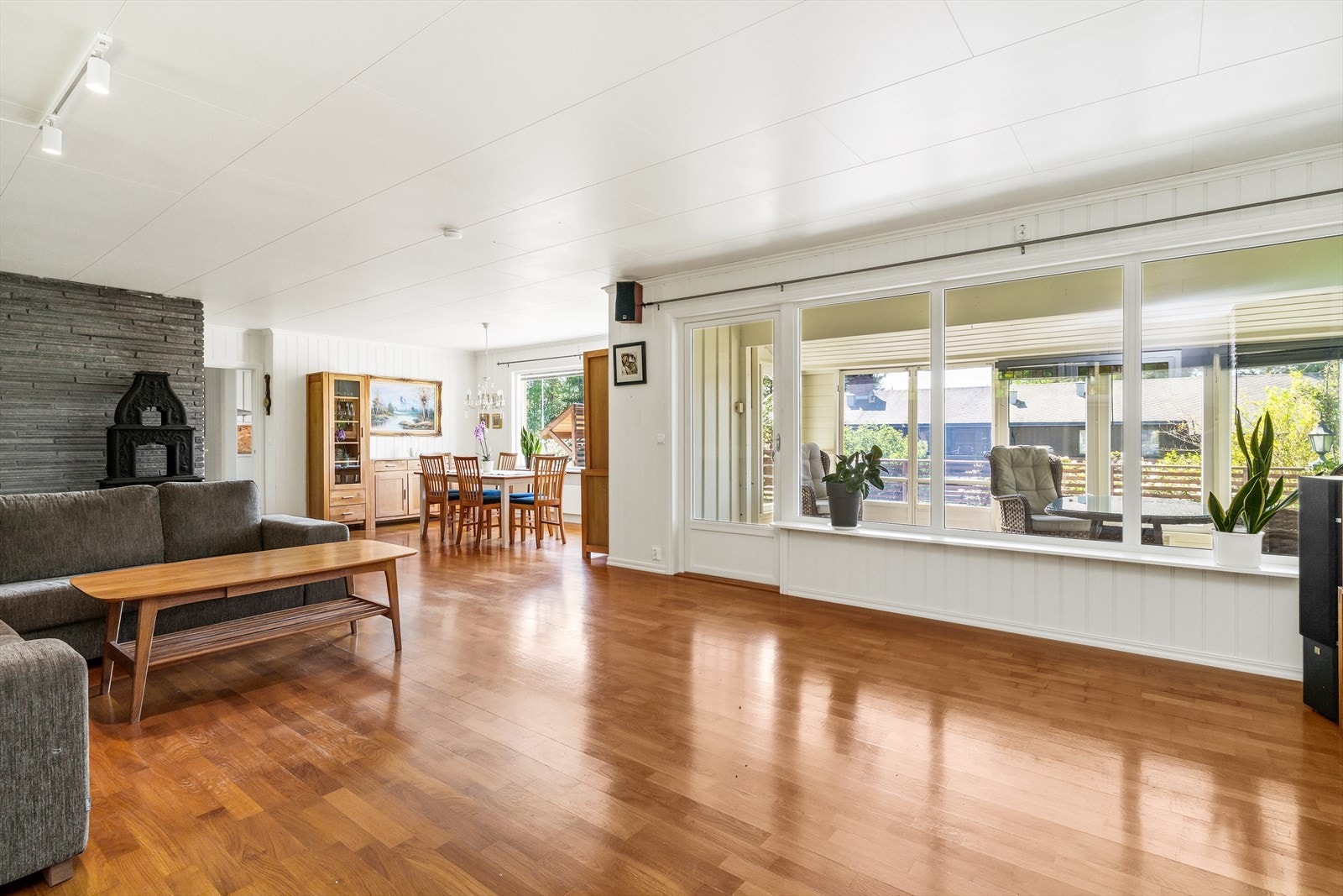 Stuen oppleves som trivelig med parkett på gulv og hvitmalt panel på vegg. Galleribilde