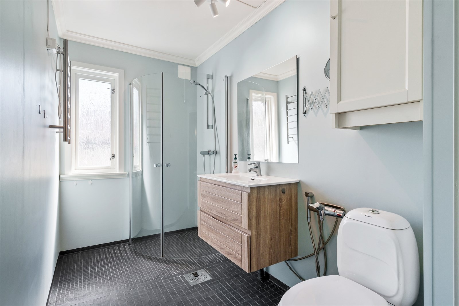 Baderom i 1.etasje med flislagt gulv og vegger med baderomspanel. Gulvet har varmekabler. Galleribilde