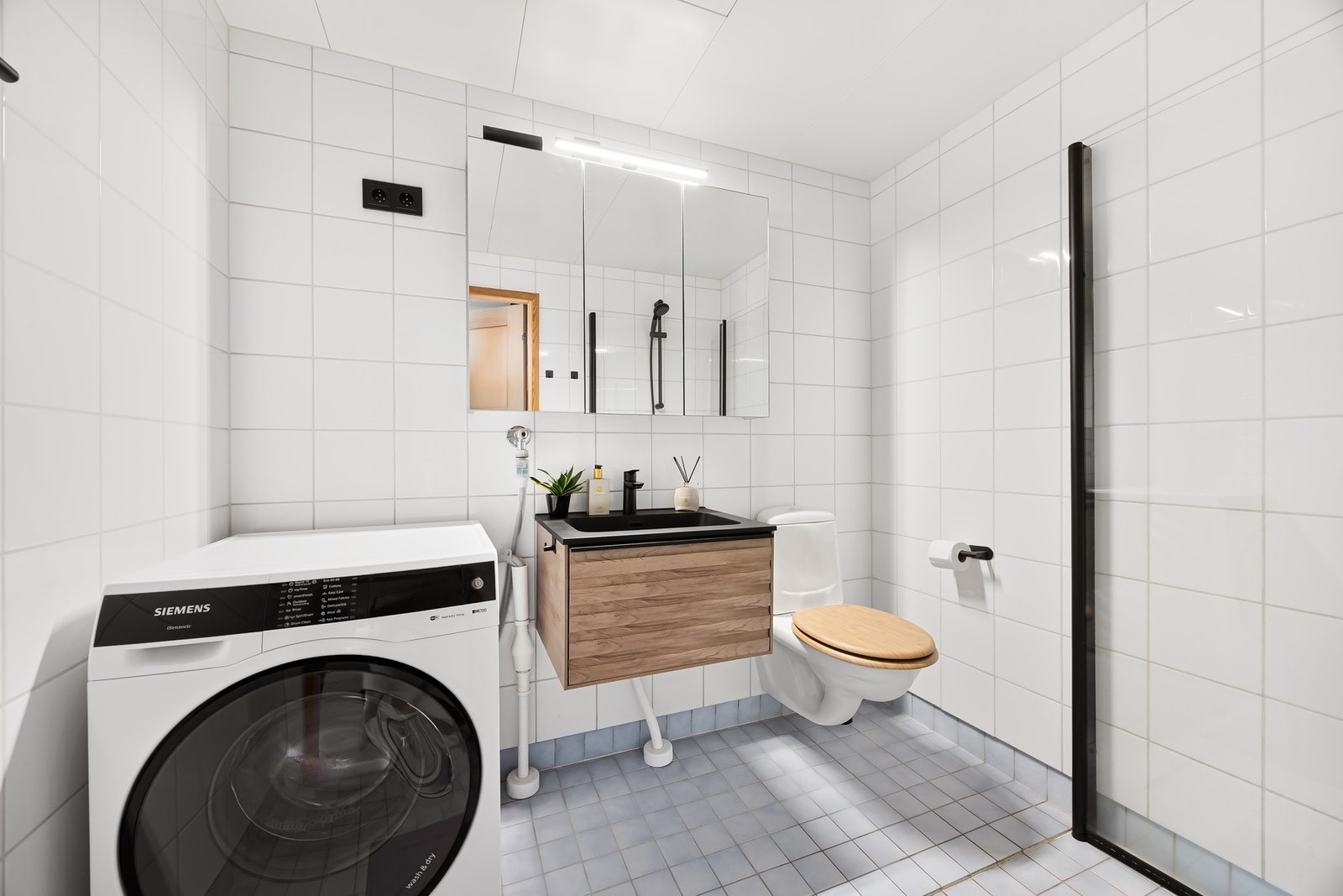 Flislagt bad med varmekabler i gulv og opplegg for vaskemaskin. Galleribilde