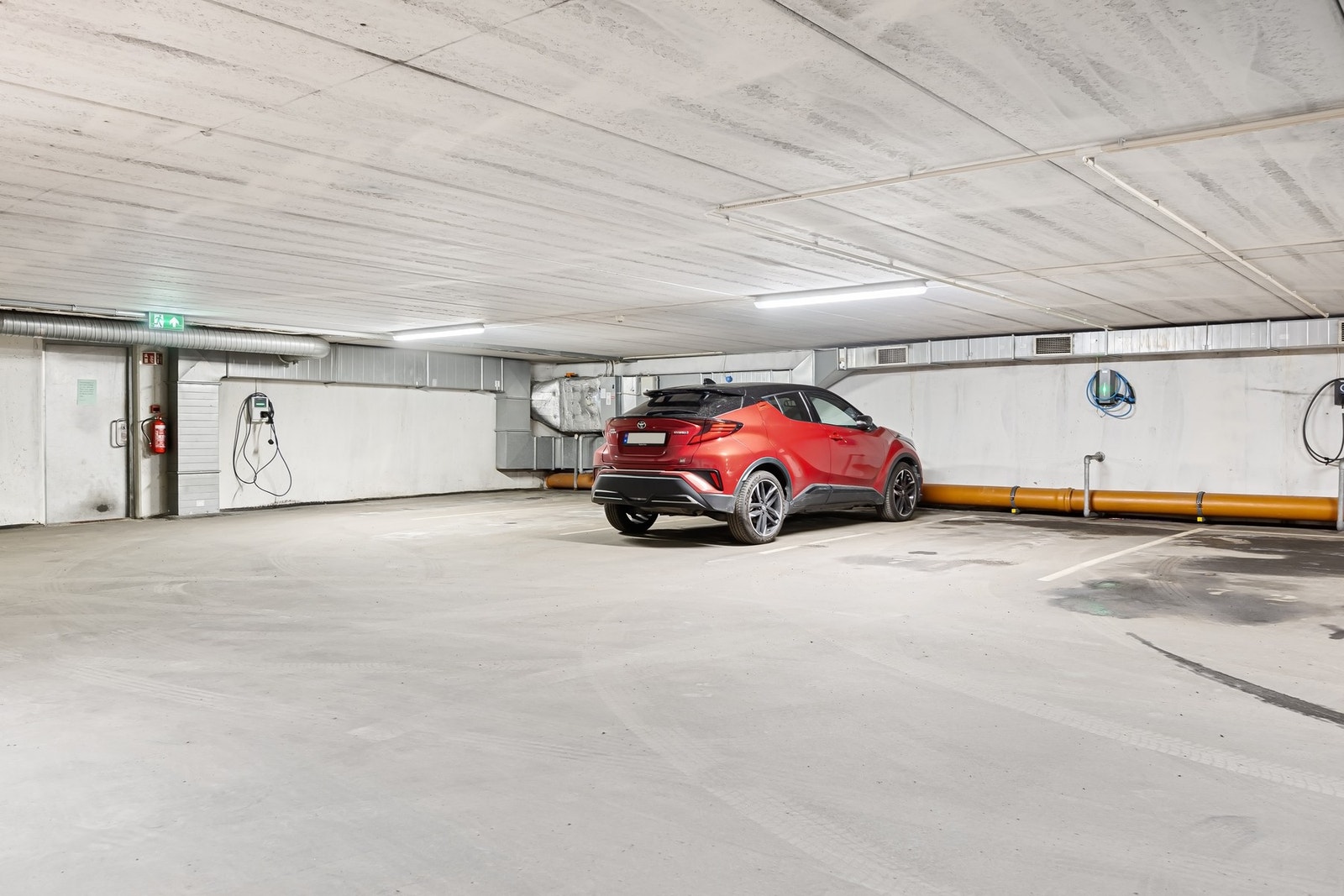 Parkeringsplass med El-bil lader i felles garasjeanlegg. Galleribilde