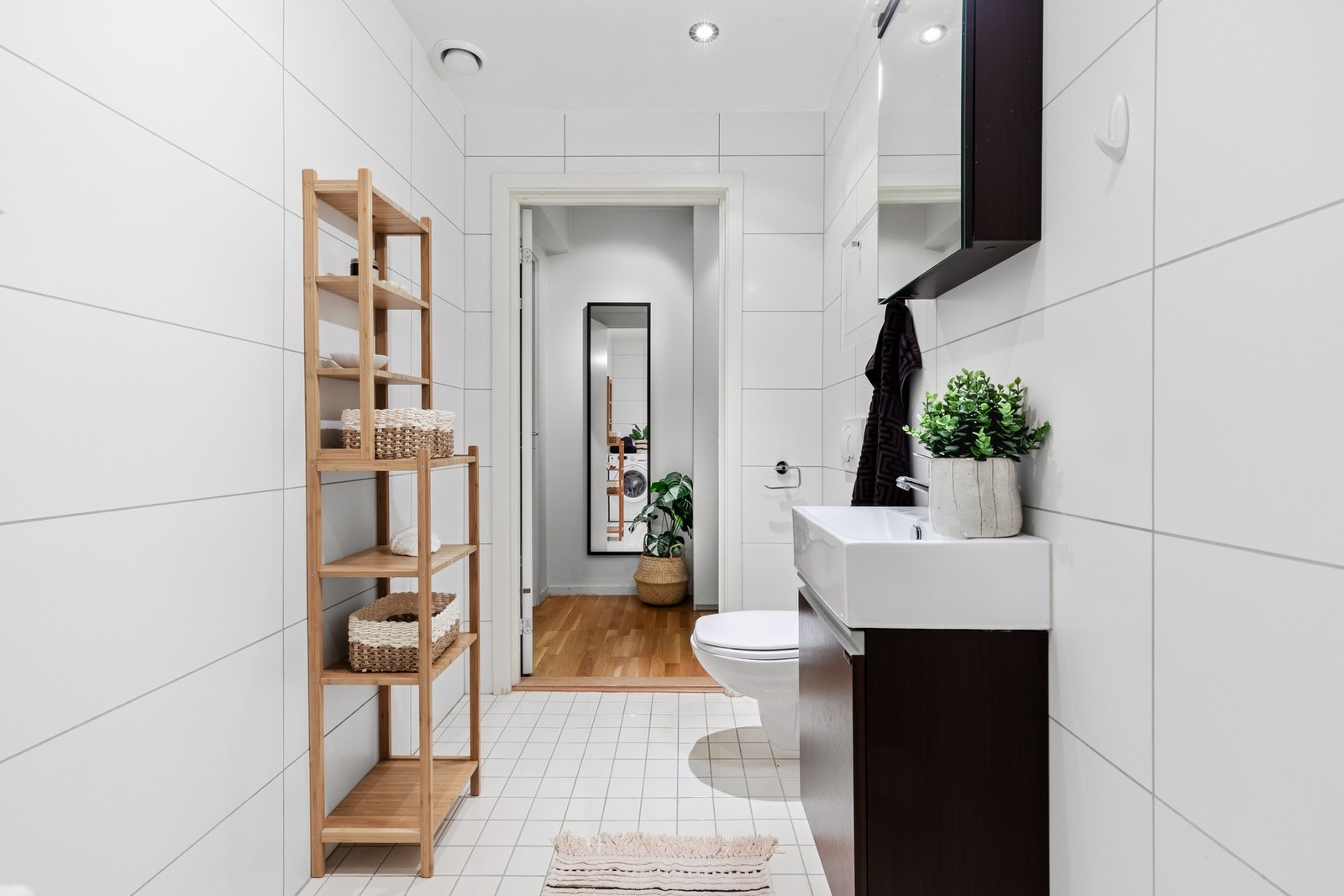 Tidløst og klassisk hvitt flisvalg og godt med plass til hylleløsninger og innredning Galleribilde