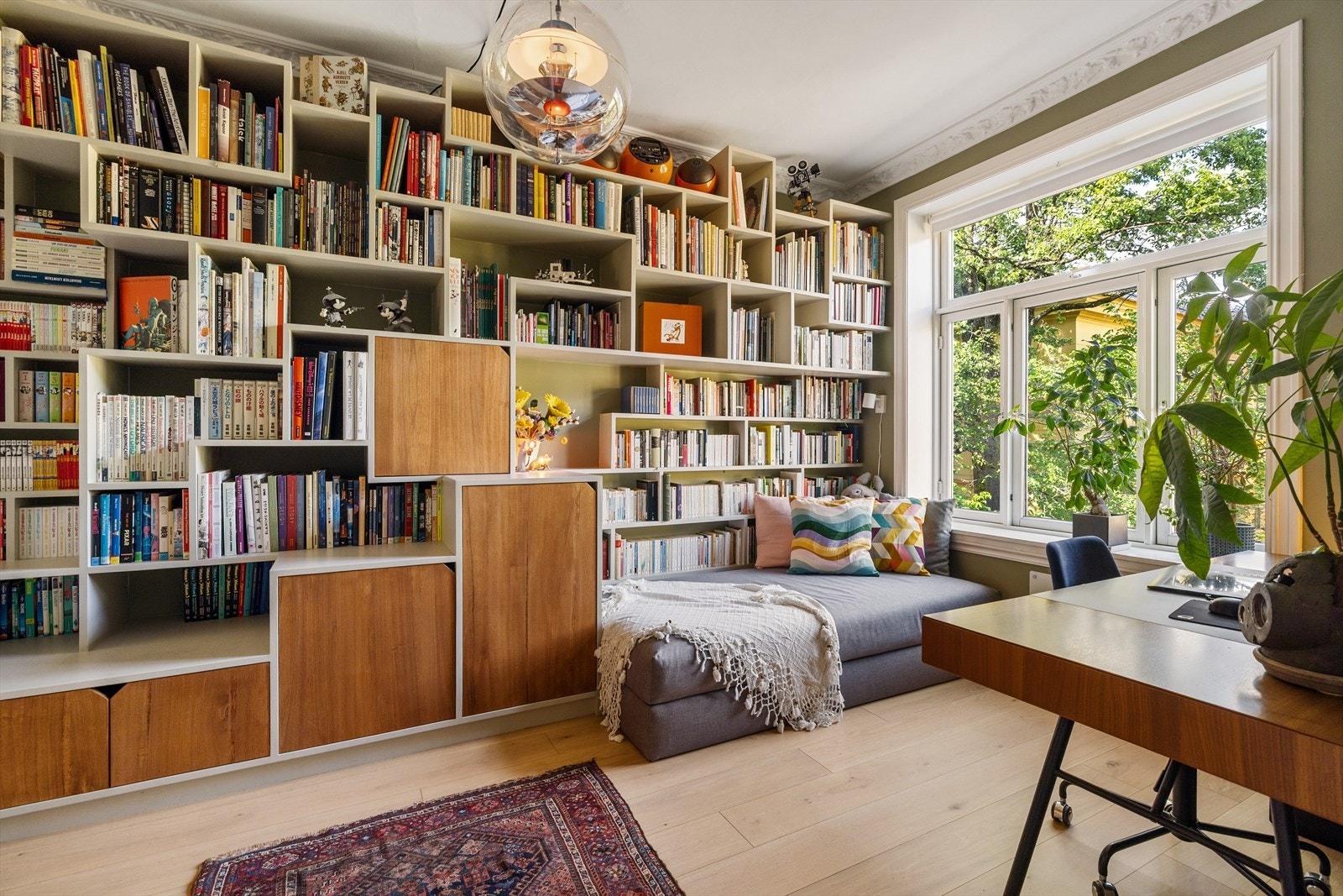 Møbelsnekret bokhylle med både oppbevaring og sofa/sengemodul. Møblet følger boligen da det er fastmontert. Galleribilde