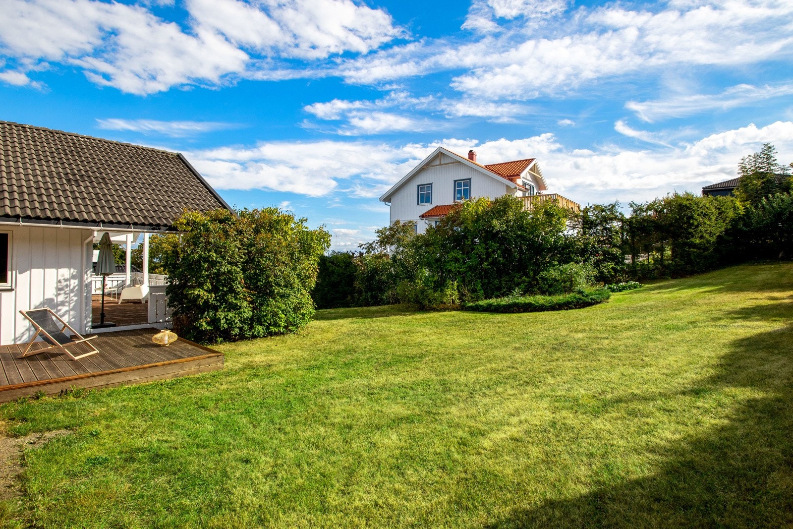 Den romslige tomten på 1 514,9 kvm er vakkert opparbeidet med velstelte prydbusker, en frodig gressplen og en velfrisert hekk som skjermer godt. Galleribilde