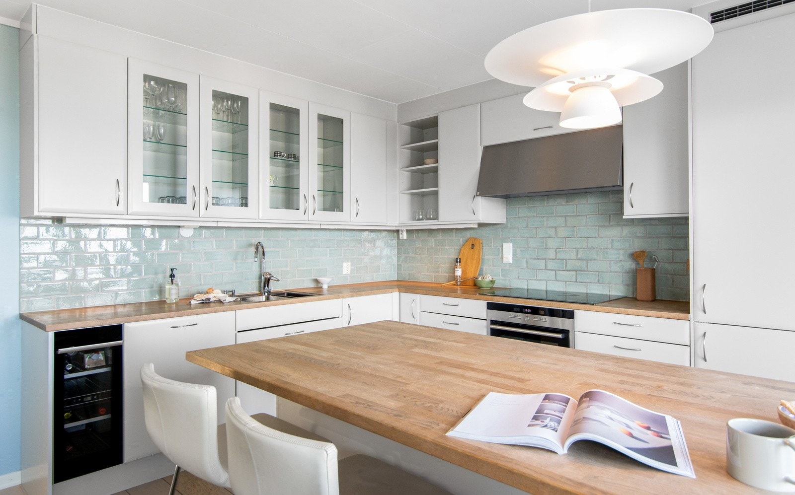 Kjøkkenøya gir ekstra arbeidsplass og samler familie og gjester rundt matlagingen i en sosial sone. Galleribilde