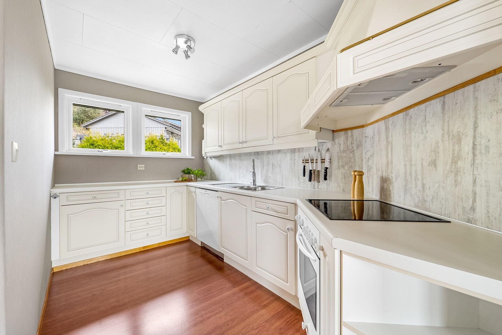 Lyst kjøkken med praktisk innredning. Vinduer gir godt med naturlig lys. Galleribilde