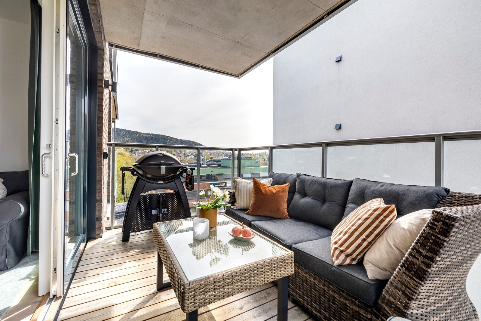 Balkongen har dekke av terrassebord, overbygg og rekkverk med sorte stålspiler, som gir et moderne og stilrent uttrykk. Galleribilde