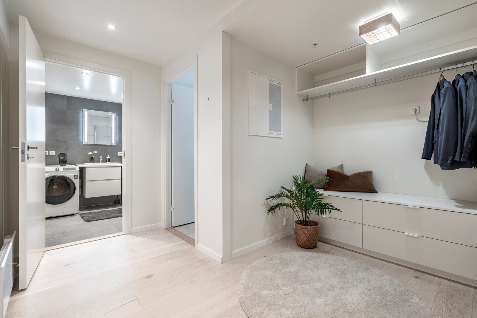 Entréen har malte vegger glatte flater, listefritt tak og enstavs parkett i hvitoljet eik, en stil som går igjen i resten av boligen. Galleribilde