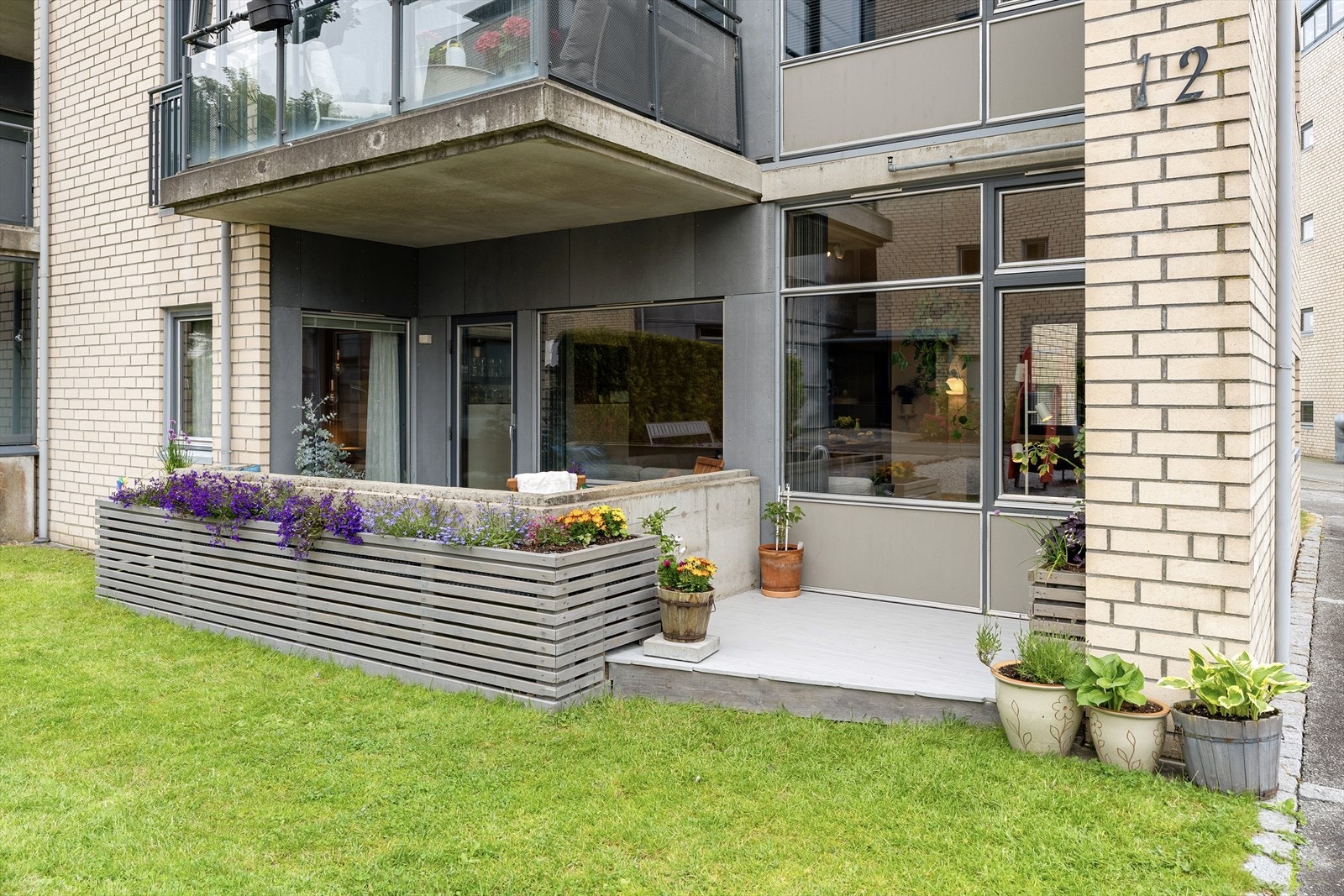 Kjekk vestvendt terrasse som grenser mot grønt fellesareal Galleribilde