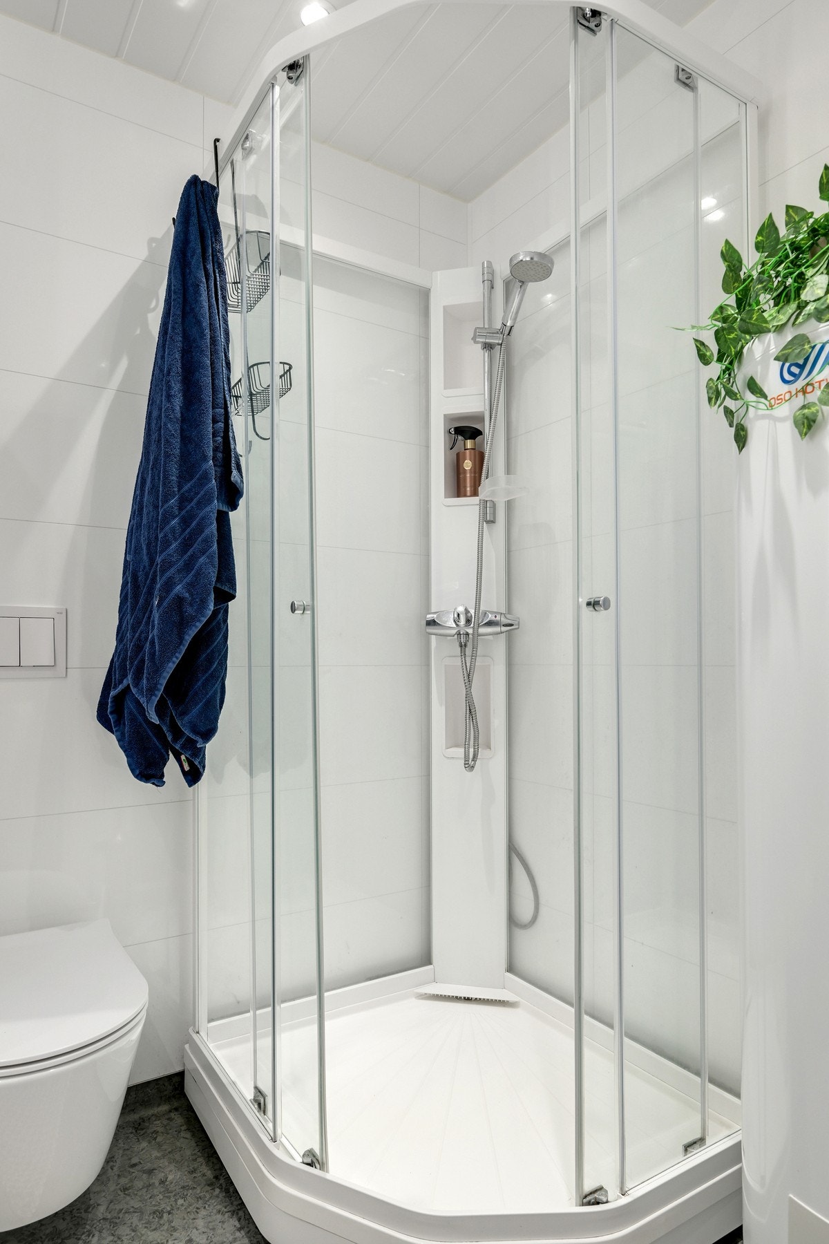 Det er varmekabler i gulvet. Badet er innredet med servant, vegghengt wc, dusjkabinett og opplegg for vaskemaskin. Galleribilde