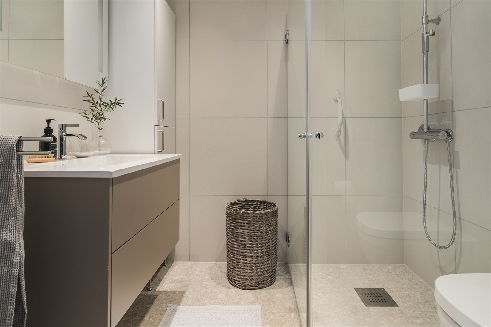 Badene har lyse fliser med varmekabler i gulv og downlights i himling, og er innredet med servantskap med to romslige skuffer og heldekkende Kuma Square servant - Det er også etablert et praktisk høyskap på badet tilknyttet hovedsoverommet Galleribilde