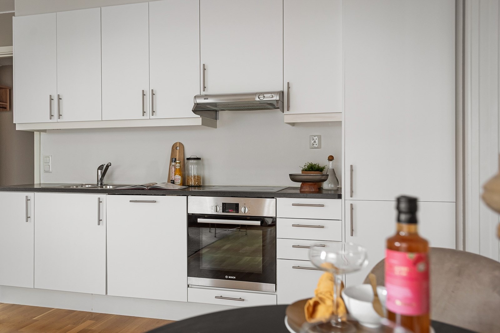 Hvitevarer fra byggeåret og moderne ventilator gir et funksjonelt kjøkkenmiljø. Galleribilde